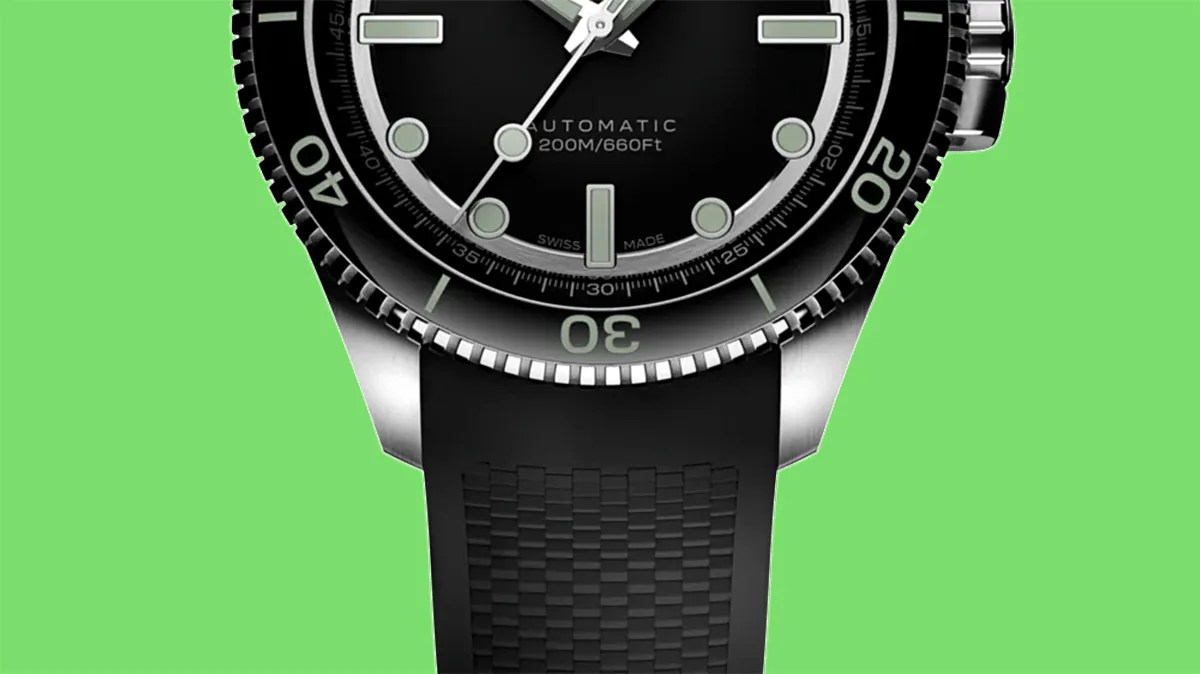 Black dive watch with rotating bezel, luminous markers, and black textured rubber strap on green background.