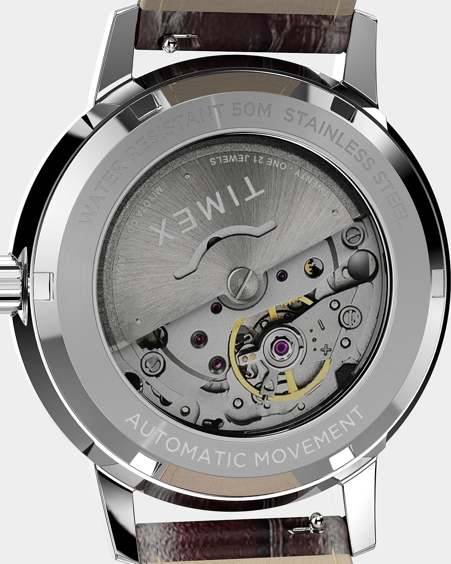 Back of a stainless steel Timex watch showing automatic movement mechanism and brown leather strap.