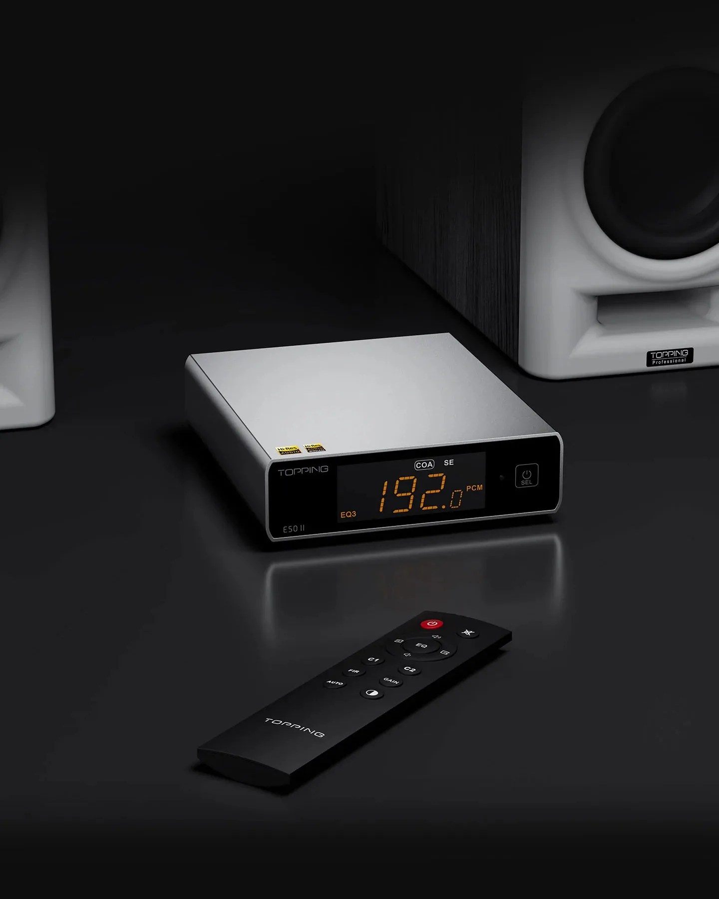 Silver Topping E50 II audio device with digital display showing "192.0 PCM" and black remote on a black surface.