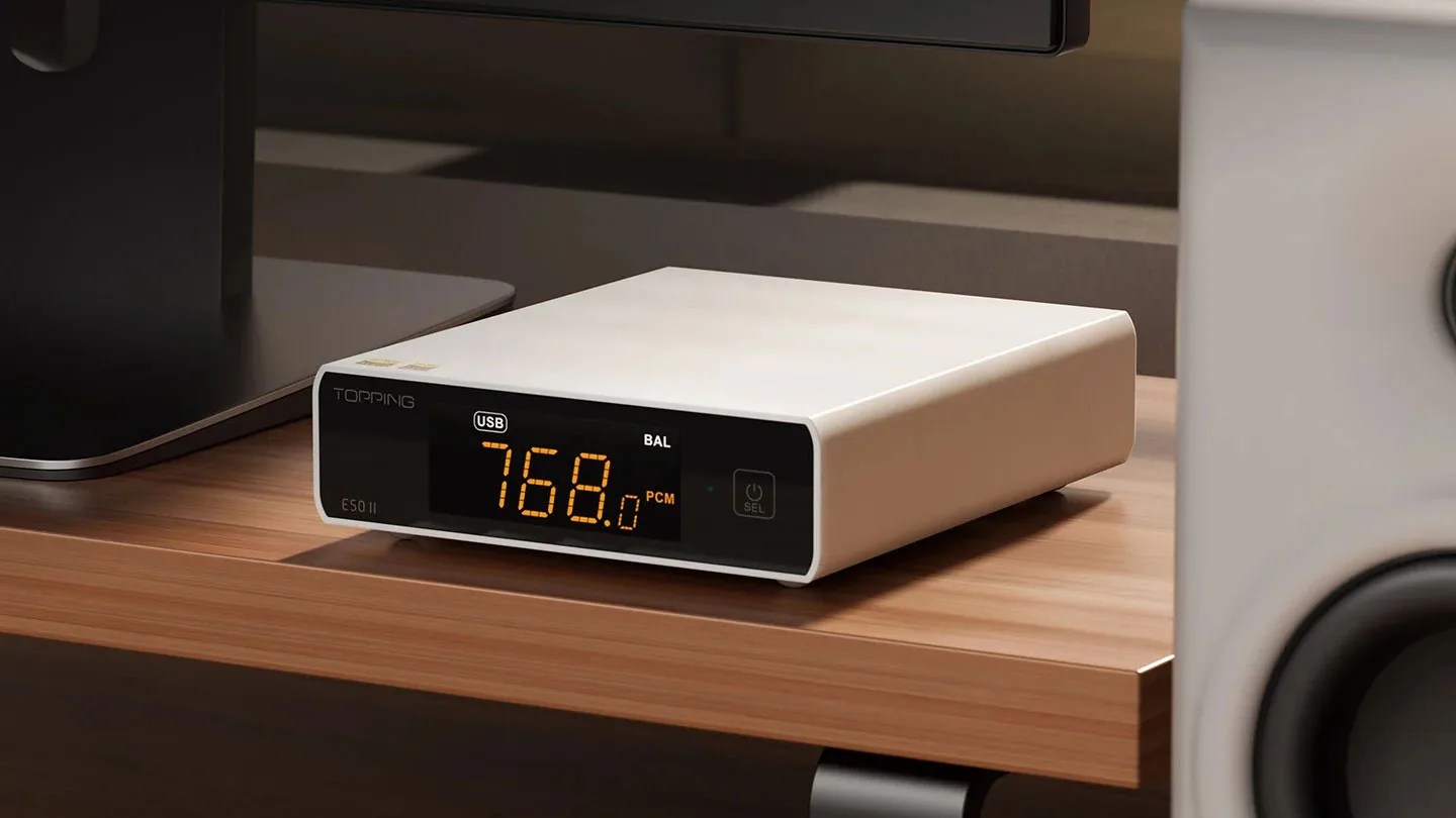 White Topping E50 II digital audio converter with orange LED display on a wooden desk.
