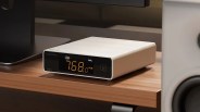 White Topping E50 II digital audio converter with orange LED display on a wooden desk.