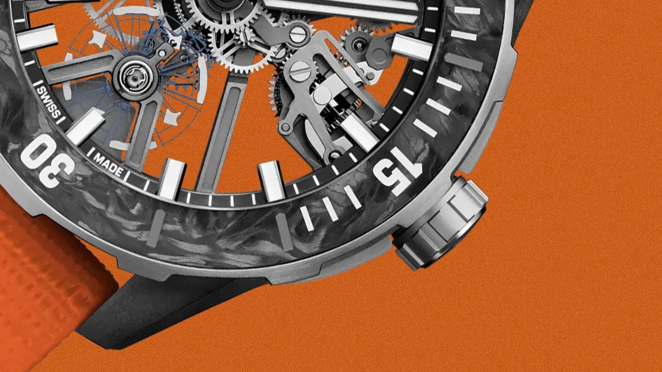Close-up of a mechanical watch with a carbon fiber bezel, visible gears, and an orange textured strap.