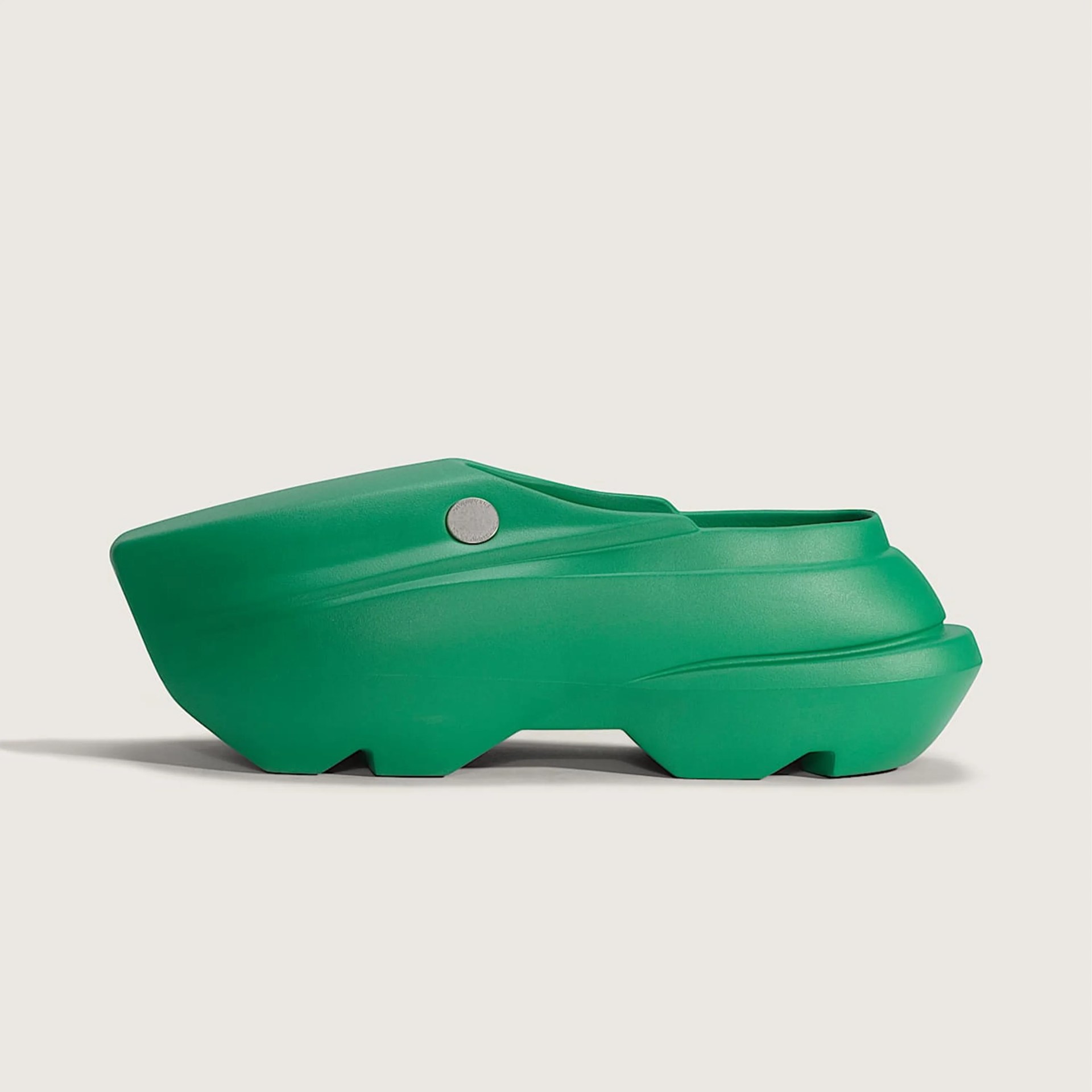 Chunky green slip-on clog with a thick sole and a small round silver button on the side.