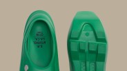 Pair of green slip-on shoes with textured soles and "S.R. STUDIO. L.A. CA. OTW by VANS" printed inside.