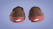 Pair of brown suede sneakers with red rubber soles and white skateboard logo on the heel.