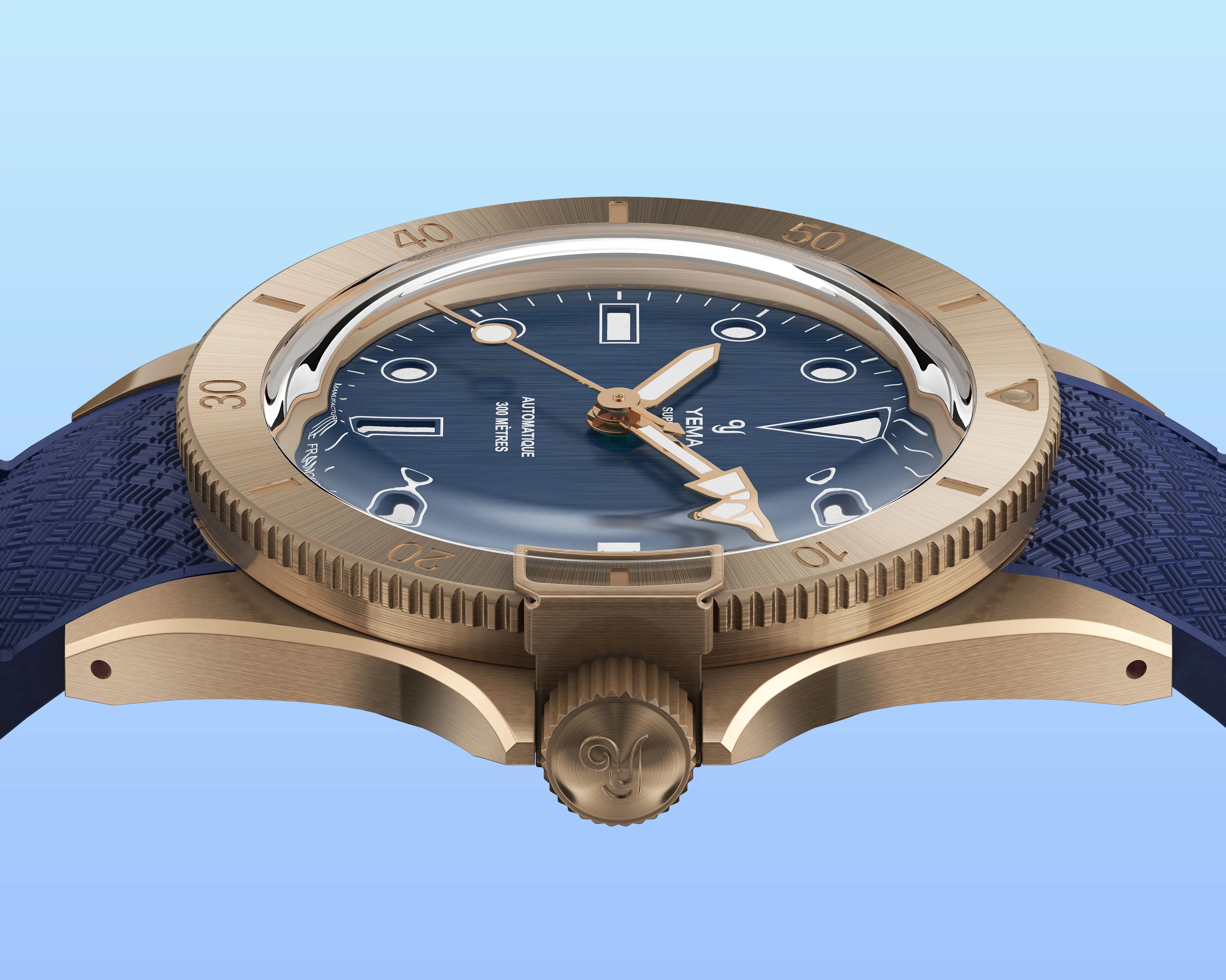 Close-up of a bronze Yema dive watch with a blue textured strap and blue dial showing gold hands and markers.