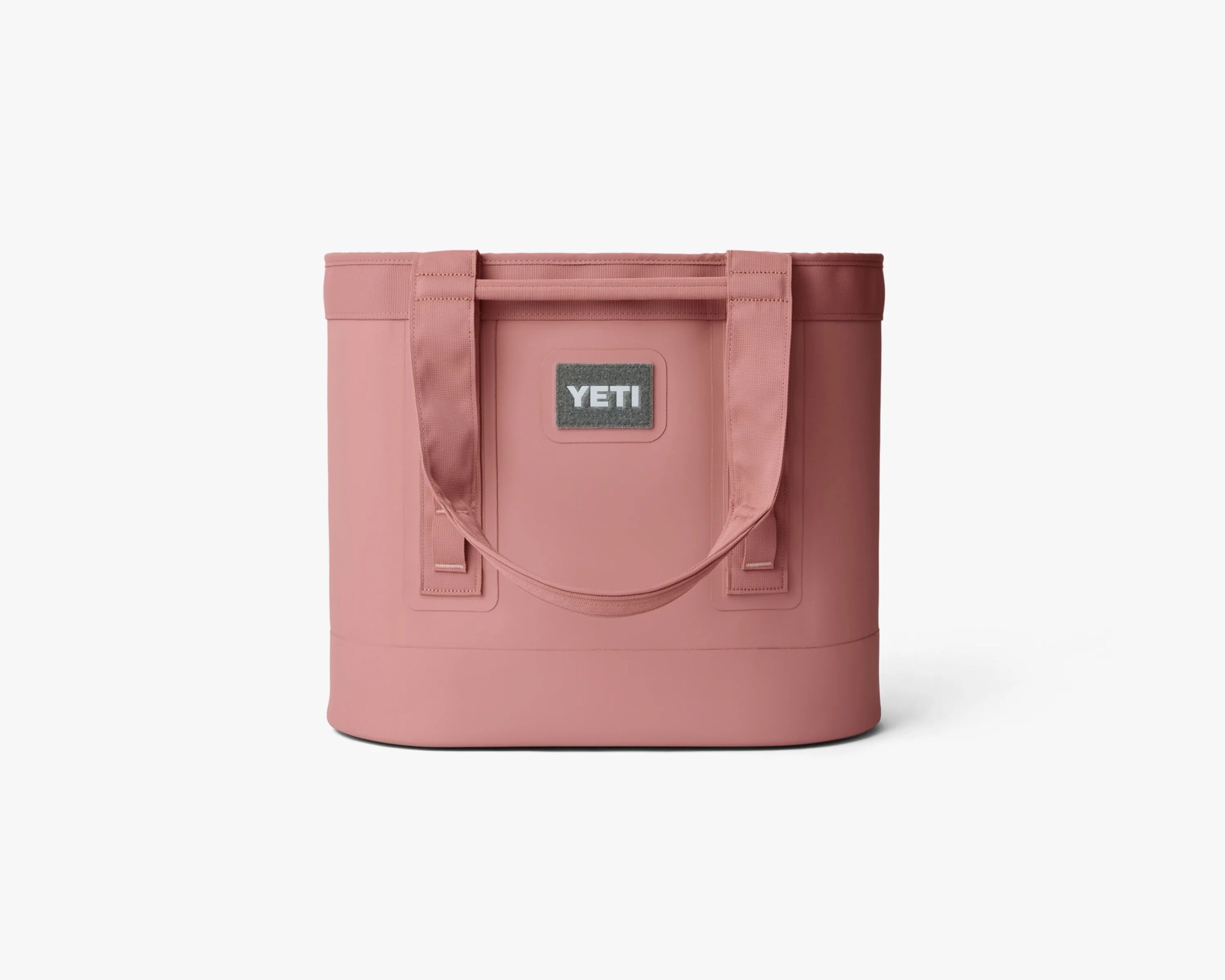 Pink YETI soft cooler bag with dual handles on a white background.
