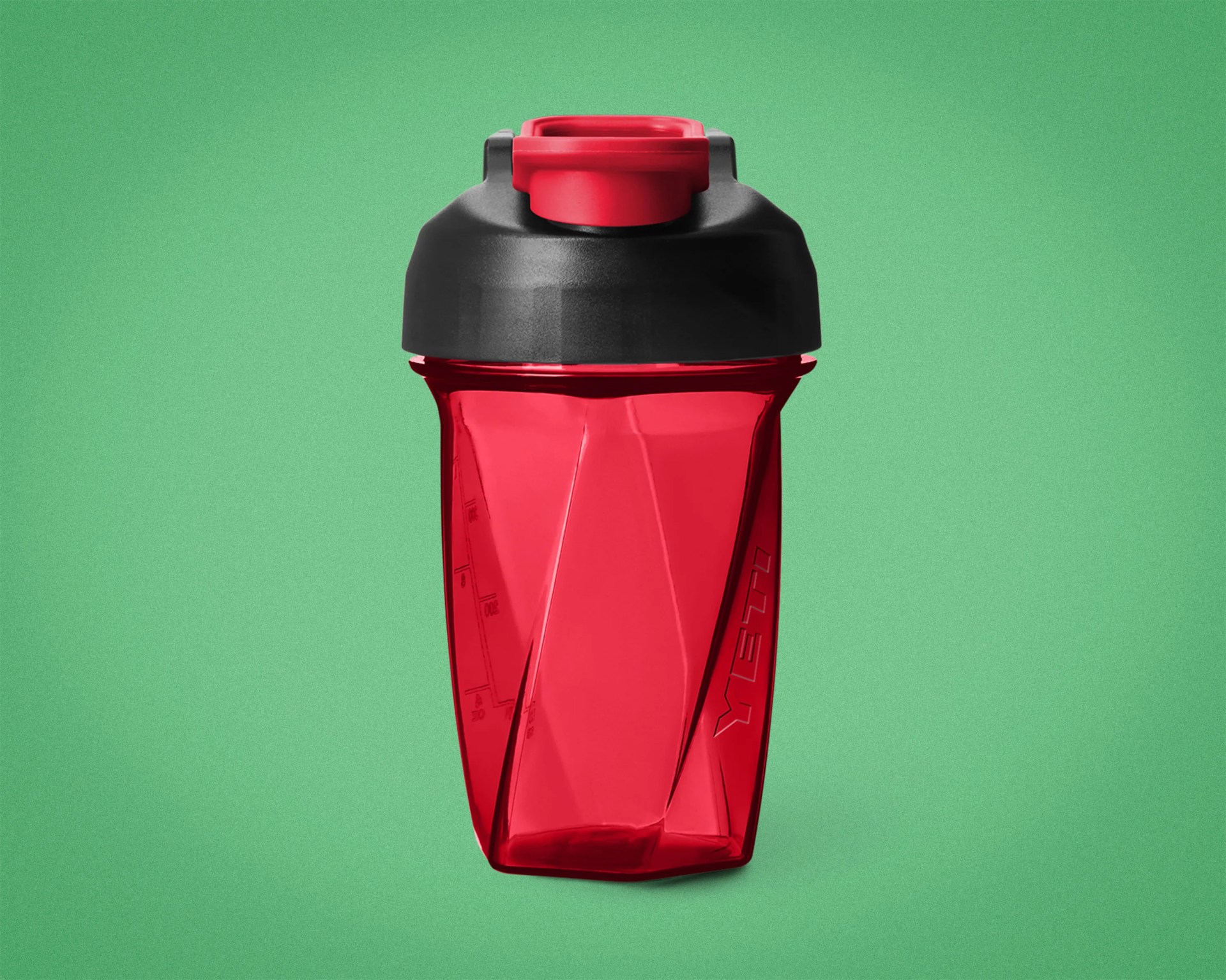 Red translucent plastic shaker bottle with black lid and red flip cap on green background.