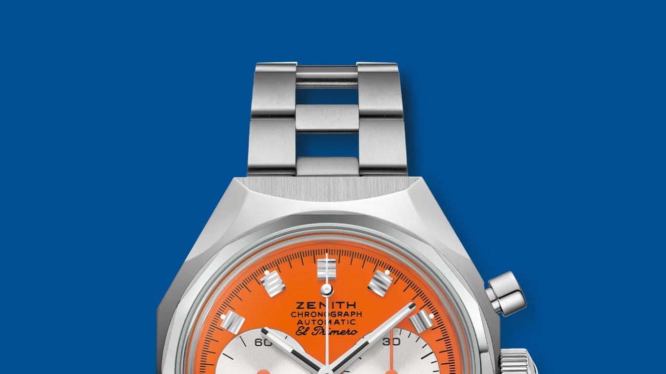 Stainless steel Zenith chronograph watch with bright orange dial and silver subdials on a metal bracelet.