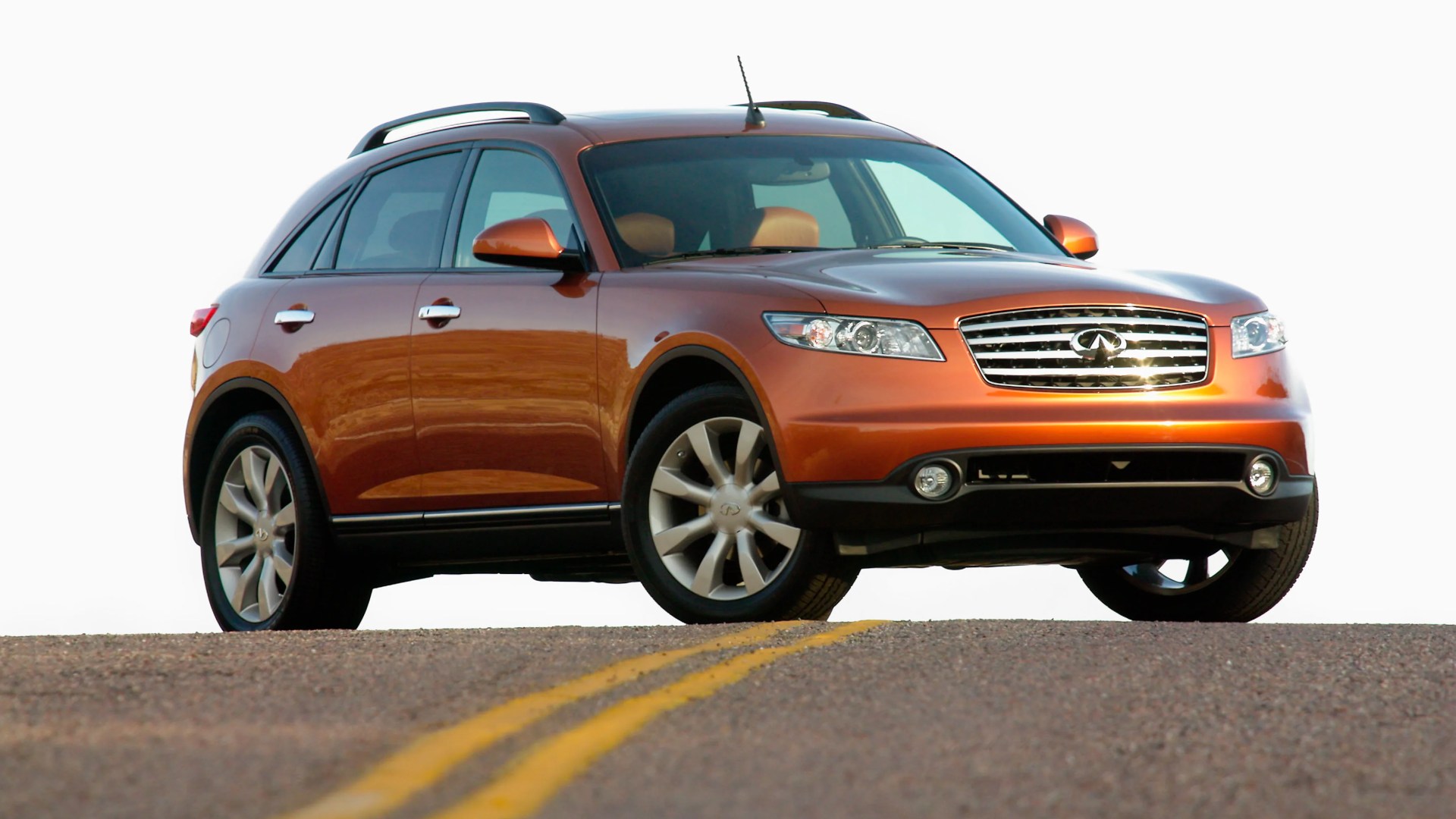 Orange Infiniti SUV parked on a road with double yellow lines, viewed from front-left angle.