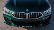 Front view of a dark green BMW Alpina car showing the kidney grille, headlights, and Alpina logo on the front lip.