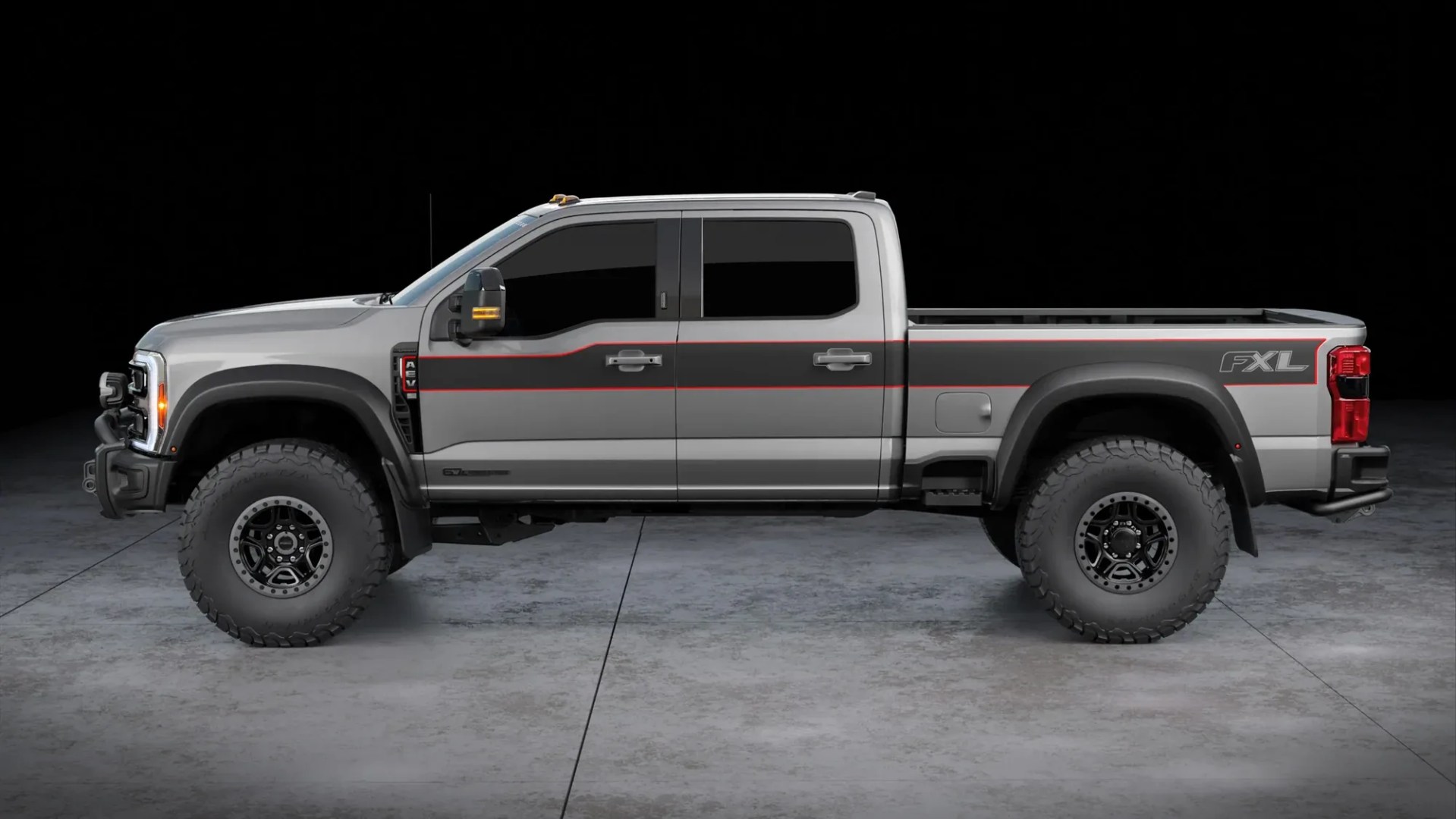 Silver and black crew cab pickup truck with large off-road tires and FXL badge on the rear side panel.