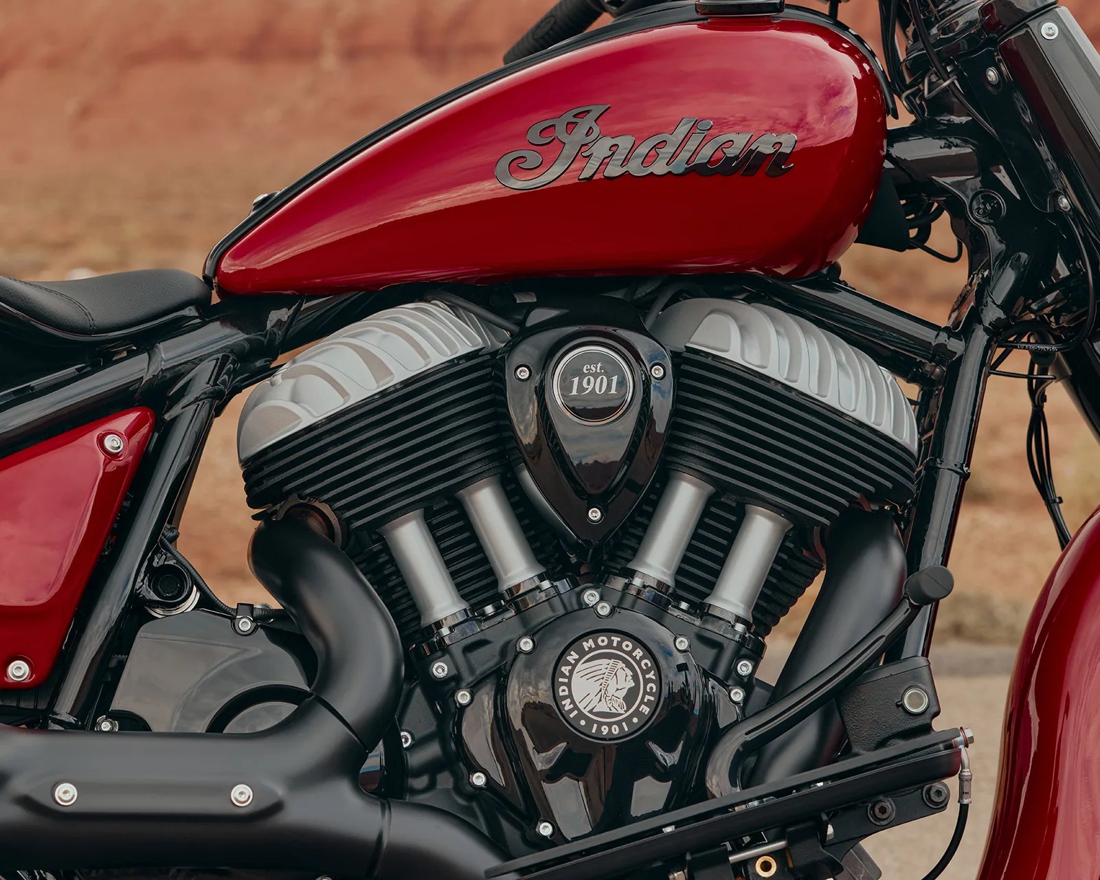 Red Indian motorcycle fuel tank with black and silver engine components and "est. 1901" emblem.