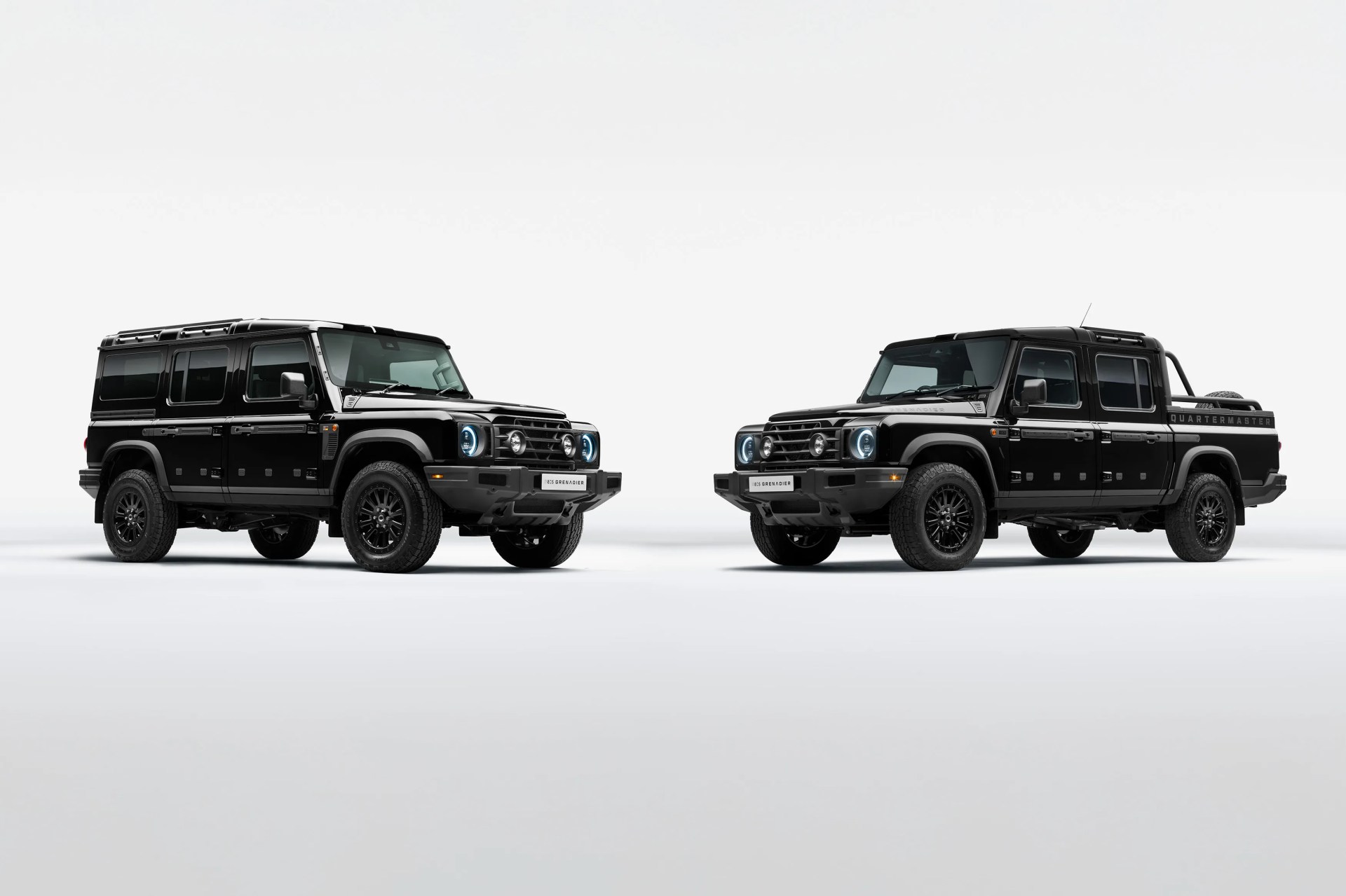 Two black Ineos Grenadier off-road vehicles, one SUV and one pickup truck, shown side by side on a white background.