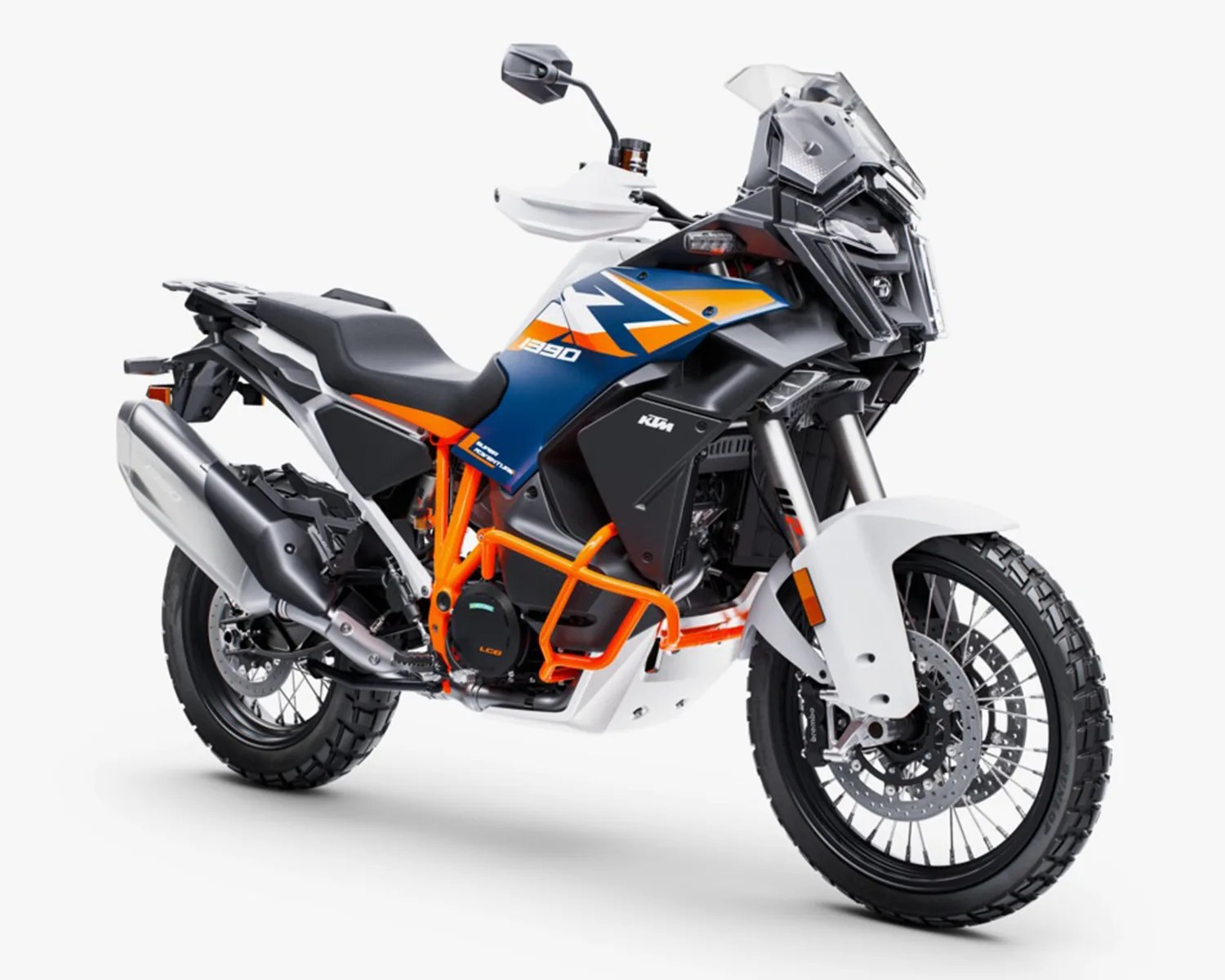 White, blue, and orange KTM 1290 adventure motorcycle with knobby tires and protective crash bars.