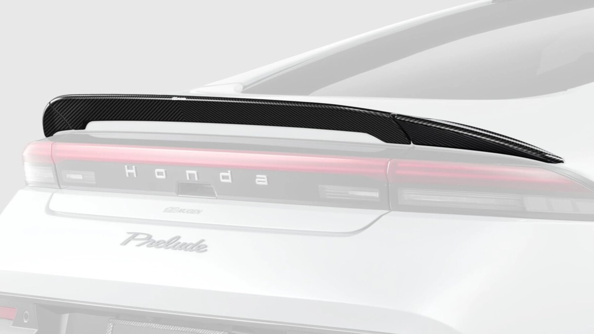 Carbon fiber rear spoiler mounted on the trunk of a white Honda Prelude car.