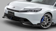 Front view of a white Honda car with Mugen license plate, black grille, blue brake calipers, and silver alloy wheels.
