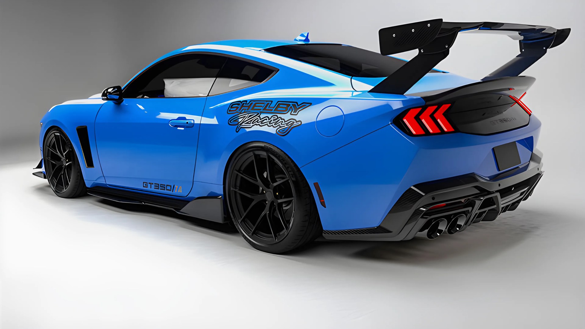 Blue Shelby Racing GT350/1A sports car with large black rear wing and black wheels on white studio floor.