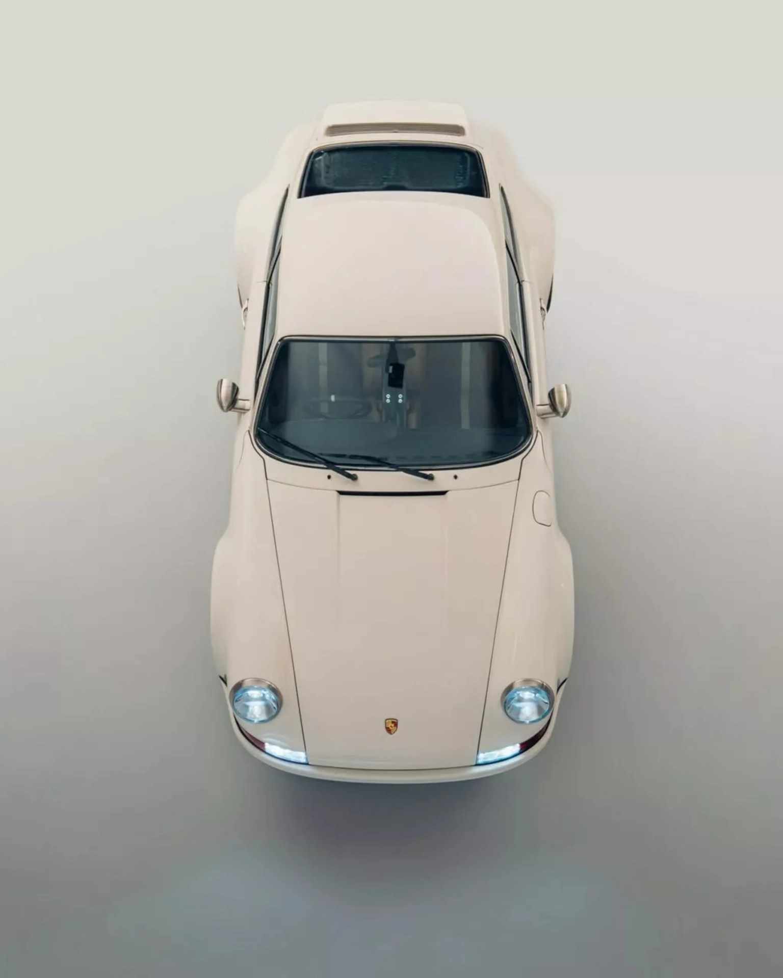 Cream-colored classic Porsche sports car viewed from above on a neutral background.