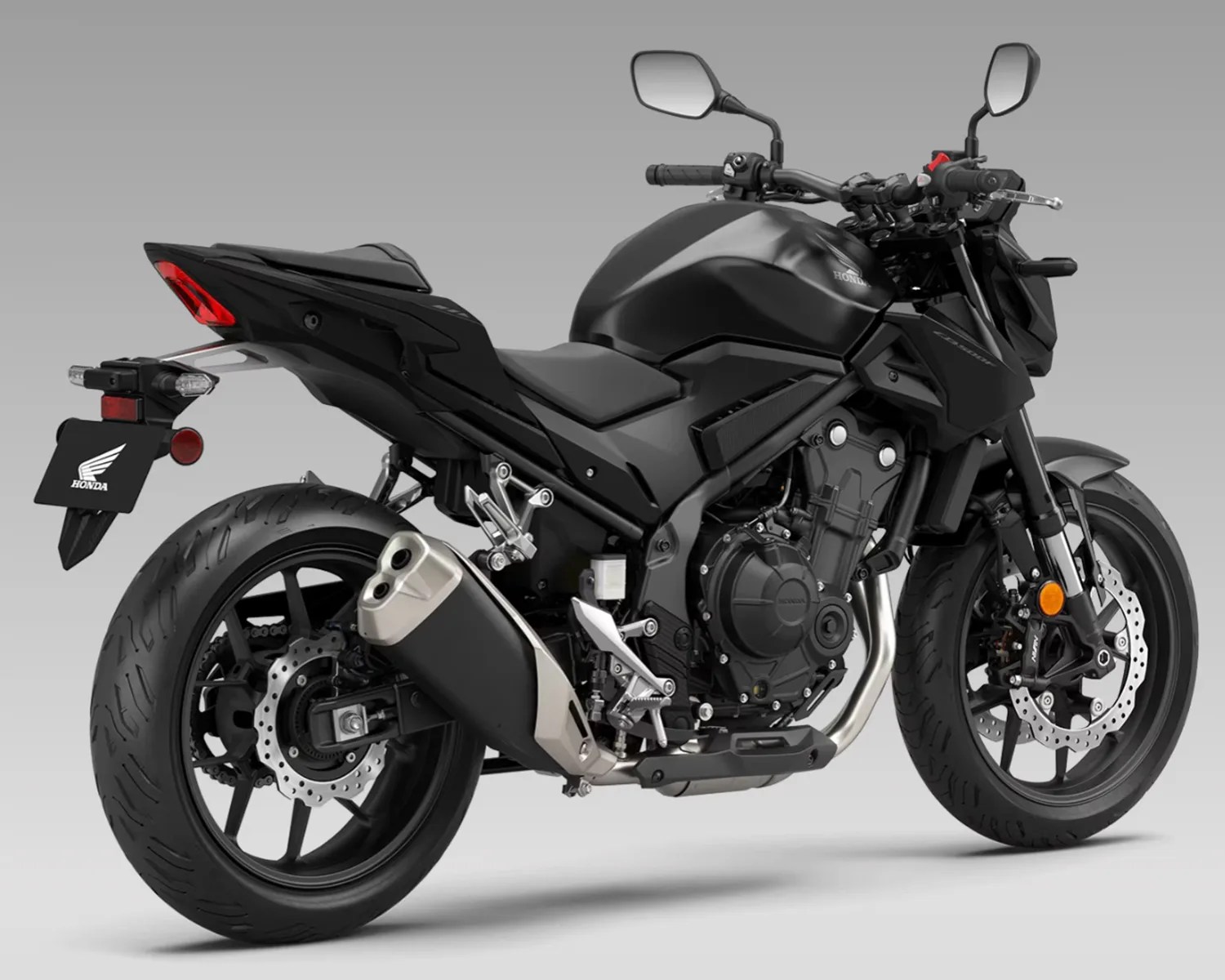 Matte black Honda sport motorcycle with dual exhaust pipes and disc brakes on both wheels.