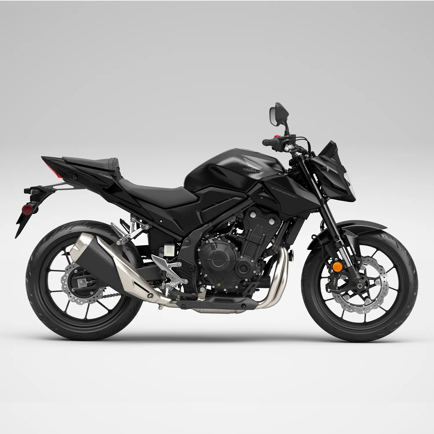 Matte black Honda sport motorcycle with silver exhaust and disc brakes on both wheels.