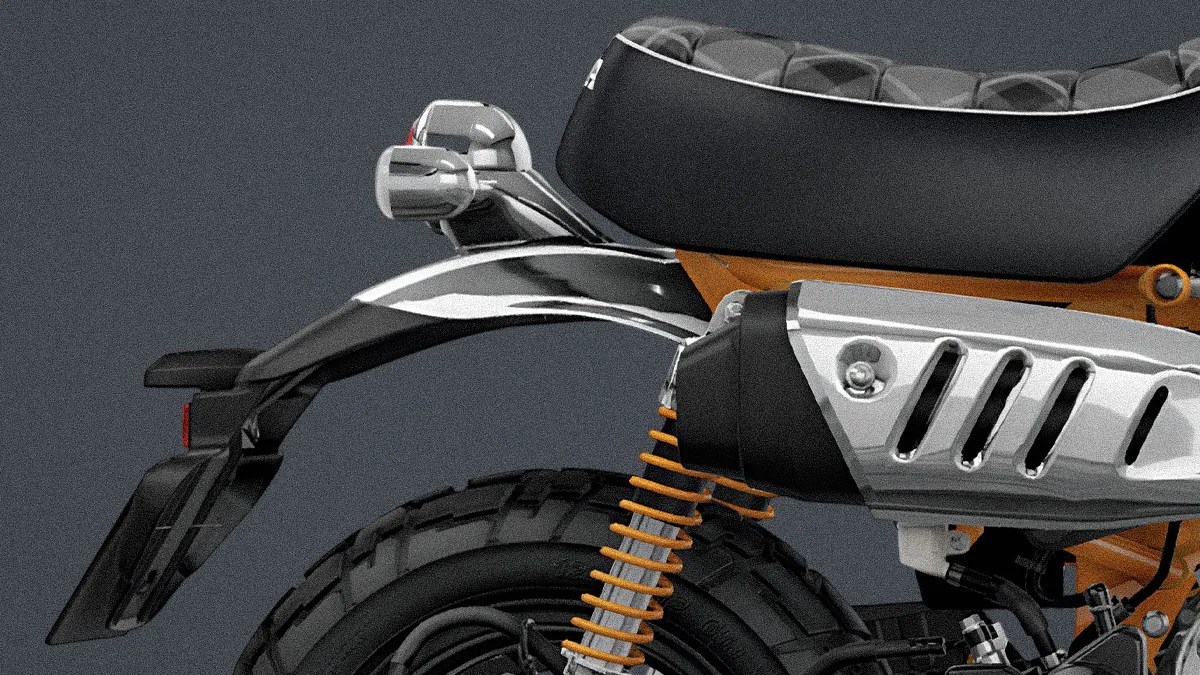 Close-up of a motorcycle's rear section showing a black seat, chrome exhaust with heat shield, orange suspension springs, and rear tire.