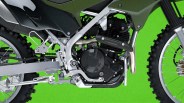 Close-up of a silver and black motorcycle engine and frame with knobby tires against a green background.