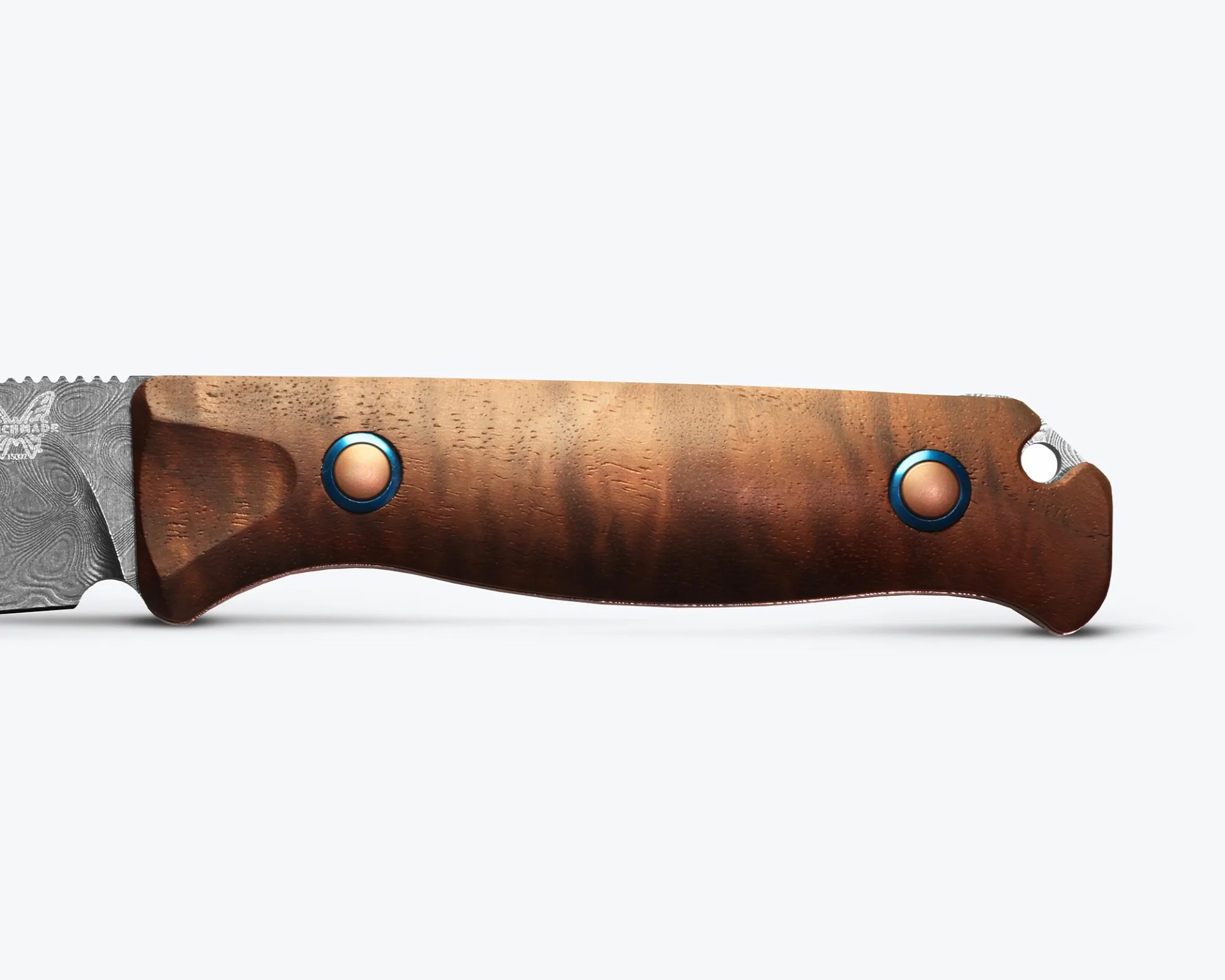 Knife handle made of polished brown wood with two blue and copper rivets and a lanyard hole.