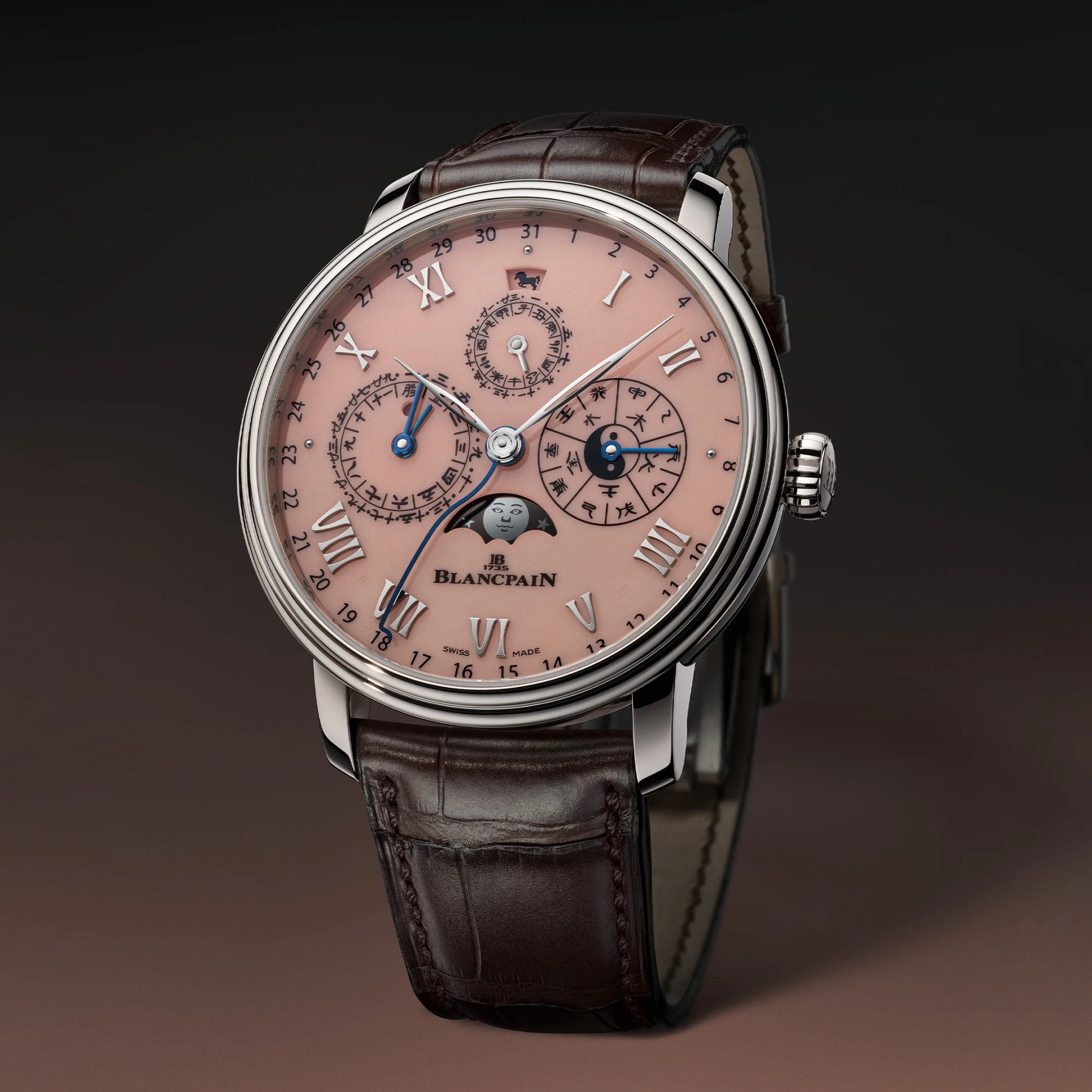 Round silver Blancpain wristwatch with pink dial, Roman numerals, moon phase display, and brown leather strap.
