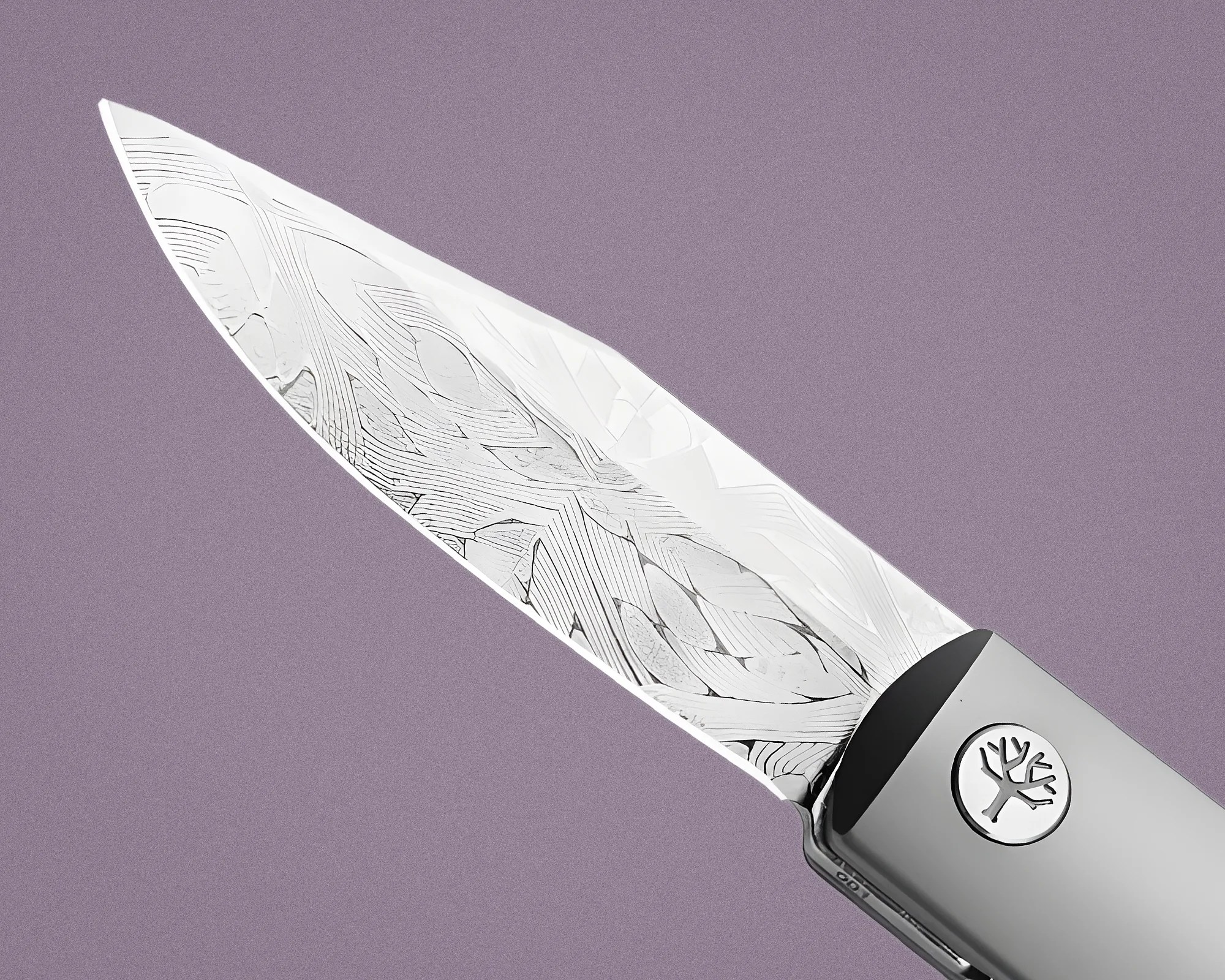 Close-up of a Damascus steel knife blade with a patterned design and a metal handle featuring a tree emblem.
