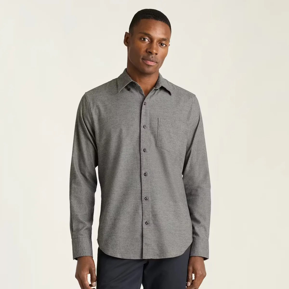 Gray long-sleeve button-up shirt with a chest pocket worn by a person.