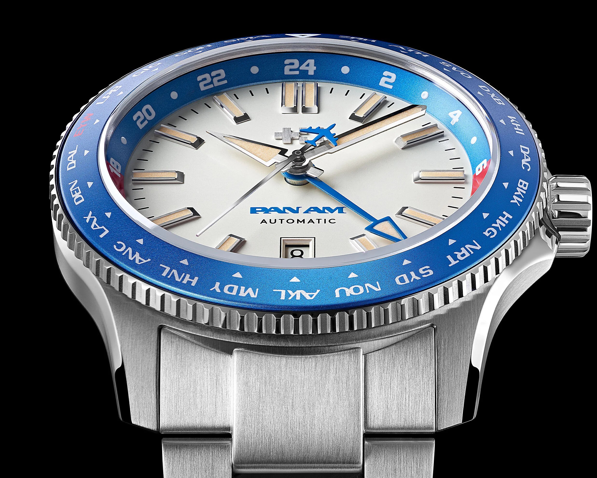 Stainless steel Pan Am automatic wristwatch with white dial, blue 24-hour bezel, and blue airplane-shaped GMT hand.