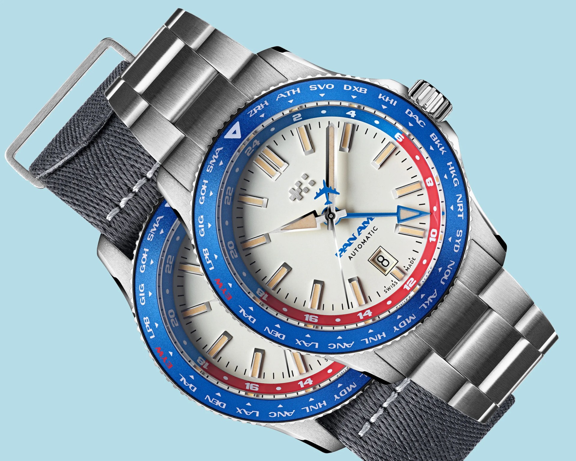 Pair of Pan Am automatic wristwatches with silver metal cases, blue and red bezels, and gray fabric and metal bands.