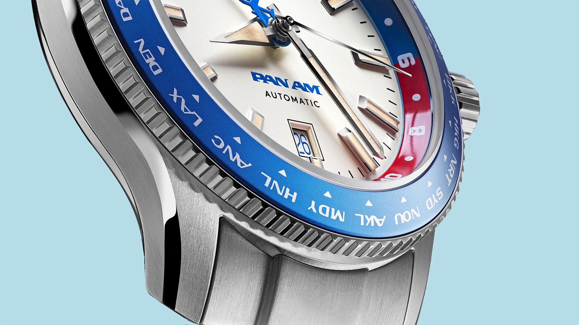Close-up of a Pan Am automatic watch with a blue and red bezel and a stainless steel case and bracelet.