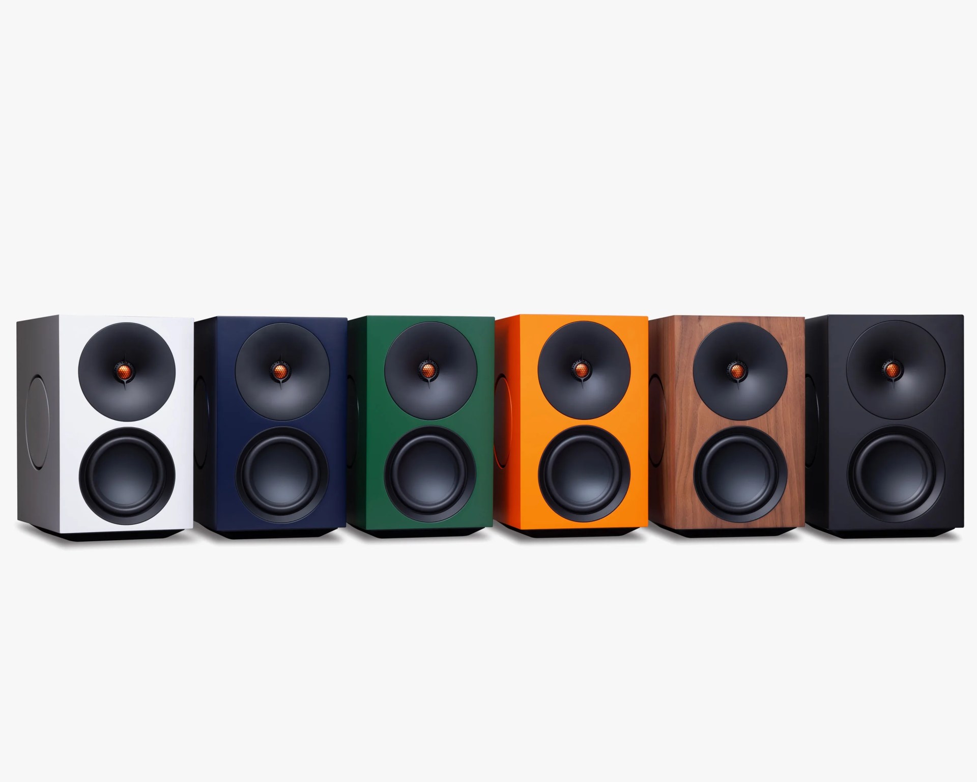 Six rectangular bookshelf speakers in white, navy, green, orange, wood finish, and black, each with a black cone and orange center tweeter.