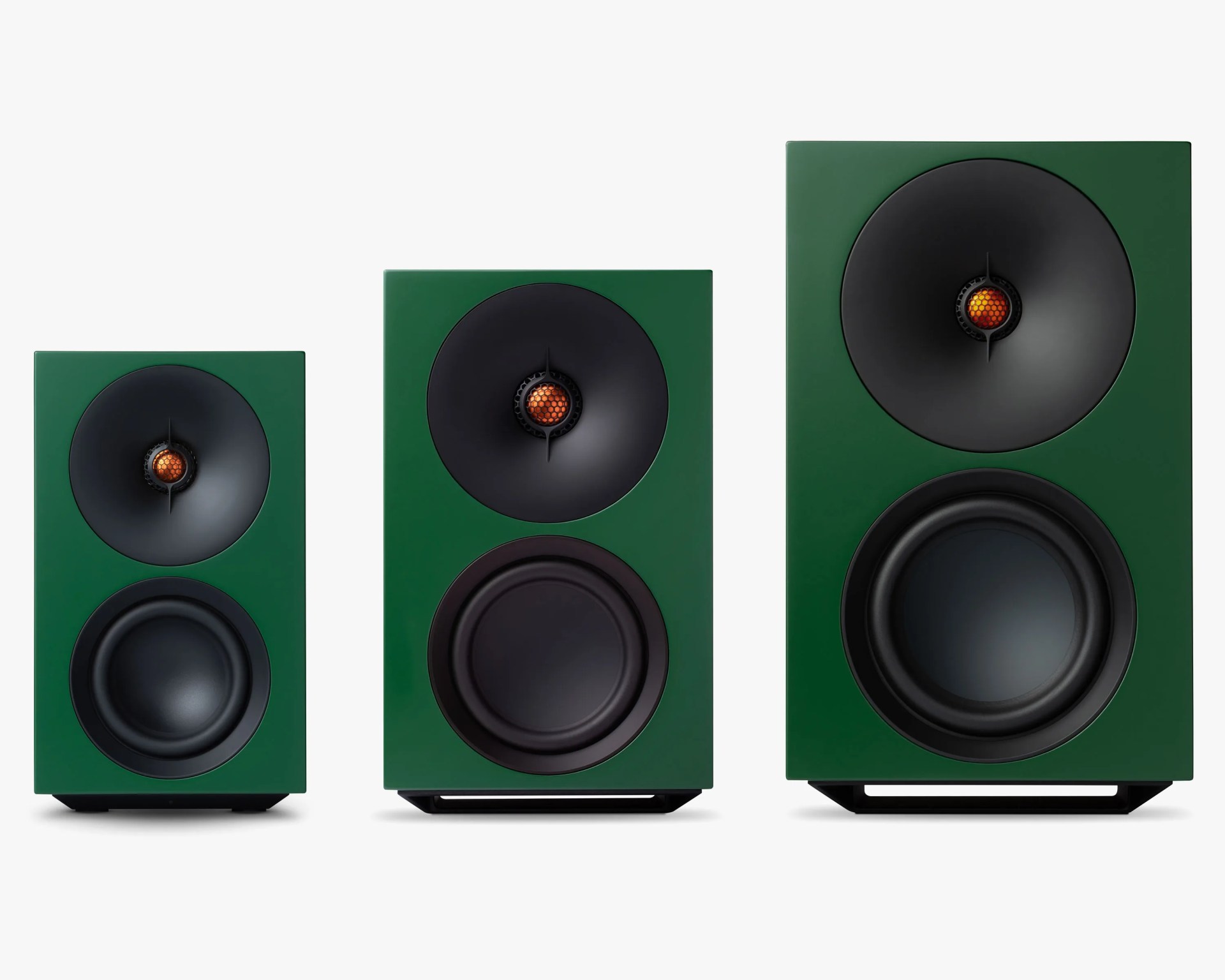 Three green rectangular speakers of different sizes with black cones and orange center tweeters arranged side by side on a white background.