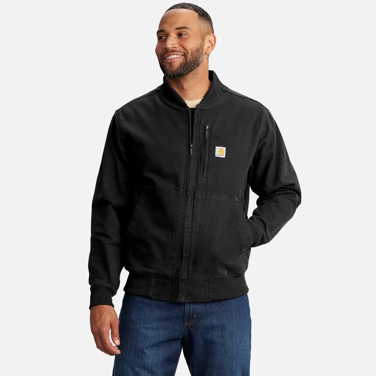 Black zip-up Carhartt jacket with ribbed cuffs and hem worn by a person.