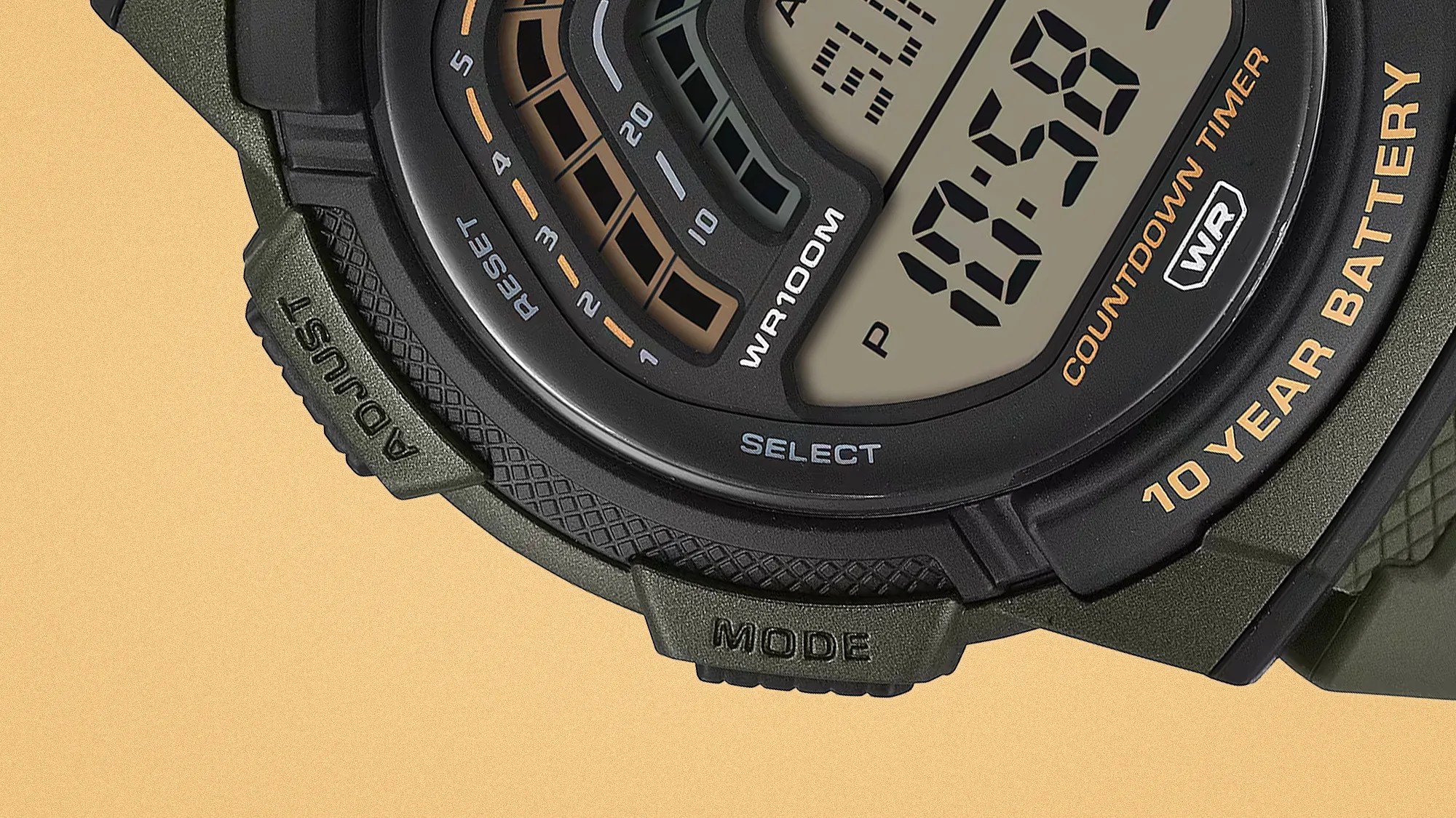 Close-up of a digital watch face showing "10 YEAR BATTERY," "WR 100M," and buttons labeled "ADJUST" and "MODE.