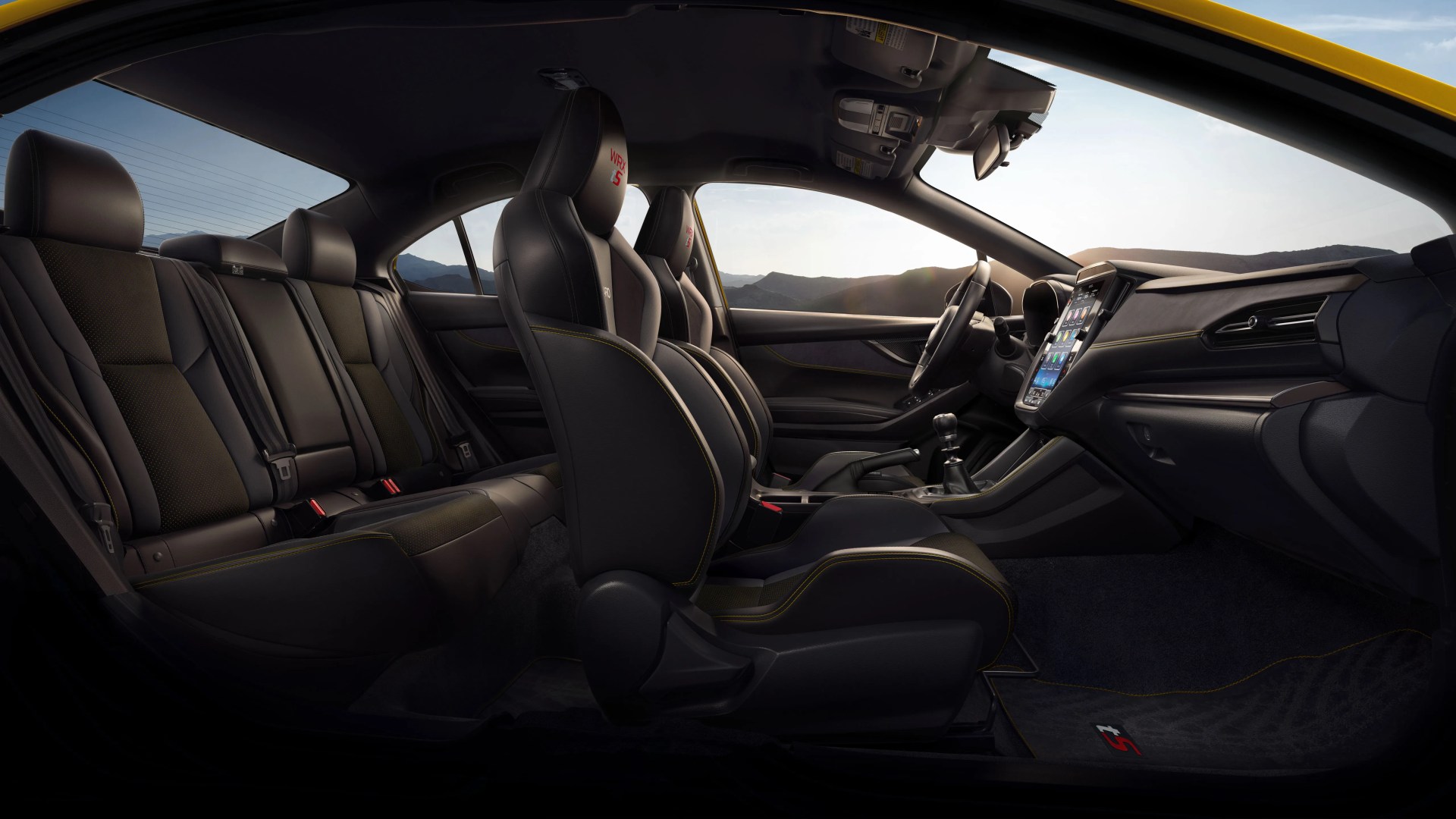 Interior of a yellow car showing black leather seats with yellow stitching and a touchscreen dashboard.