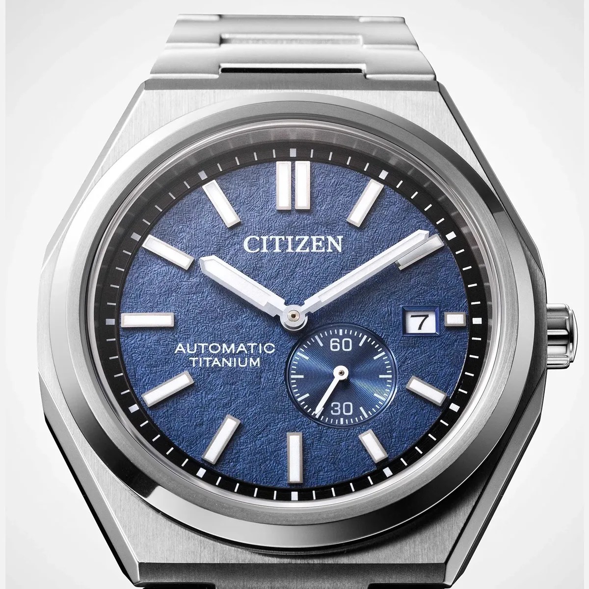 Silver Citizen automatic titanium wristwatch with textured blue dial and date window at 3 o'clock.