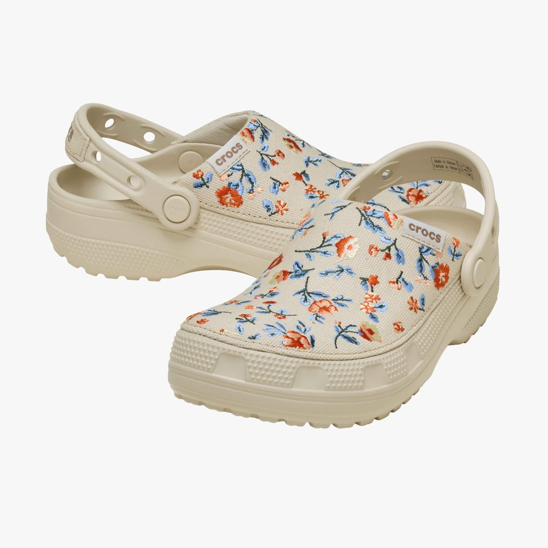 Beige Crocs clogs with orange and blue floral pattern and adjustable heel straps.
