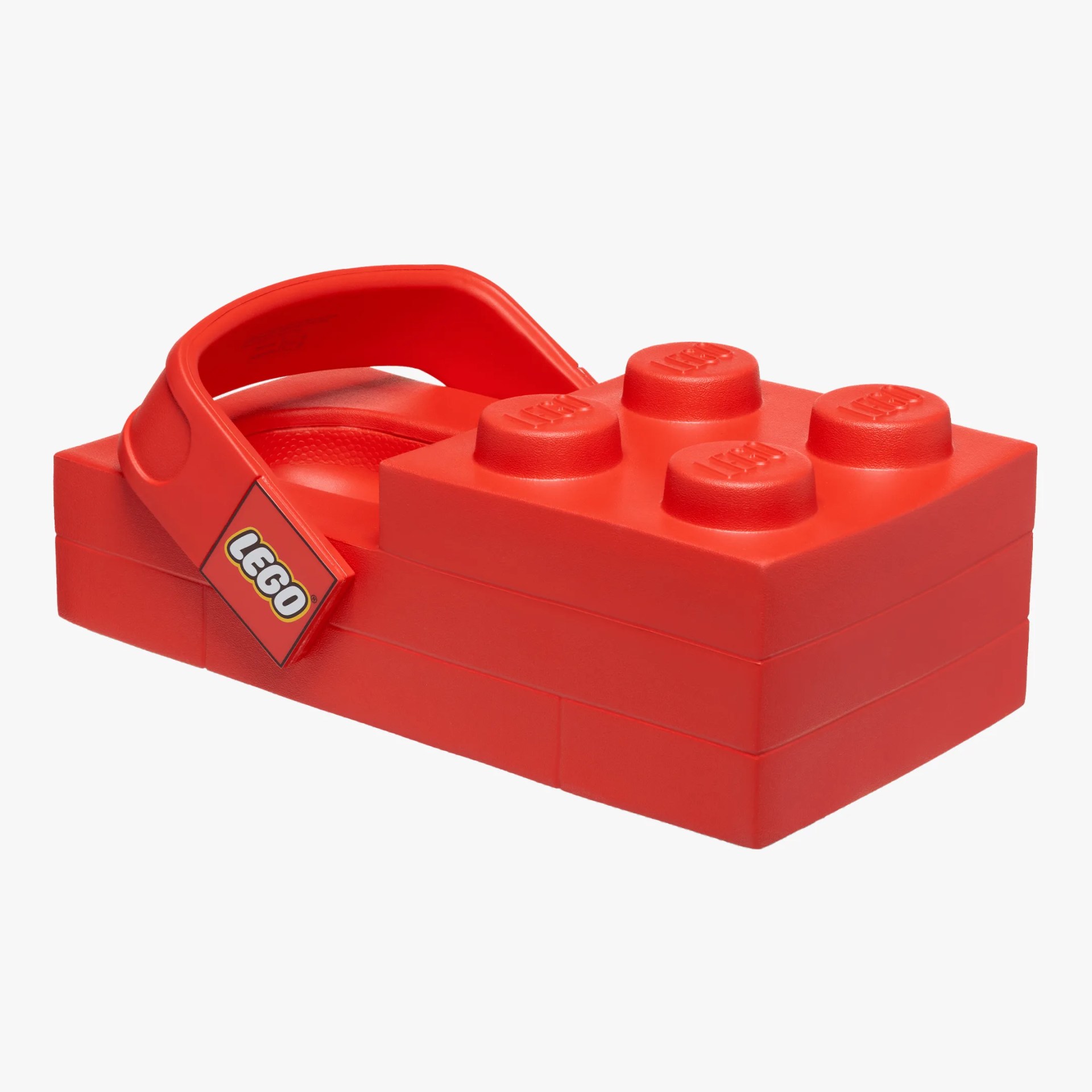 Red LEGO-themed slide sandal with a block-shaped sole and a LEGO logo on the strap.