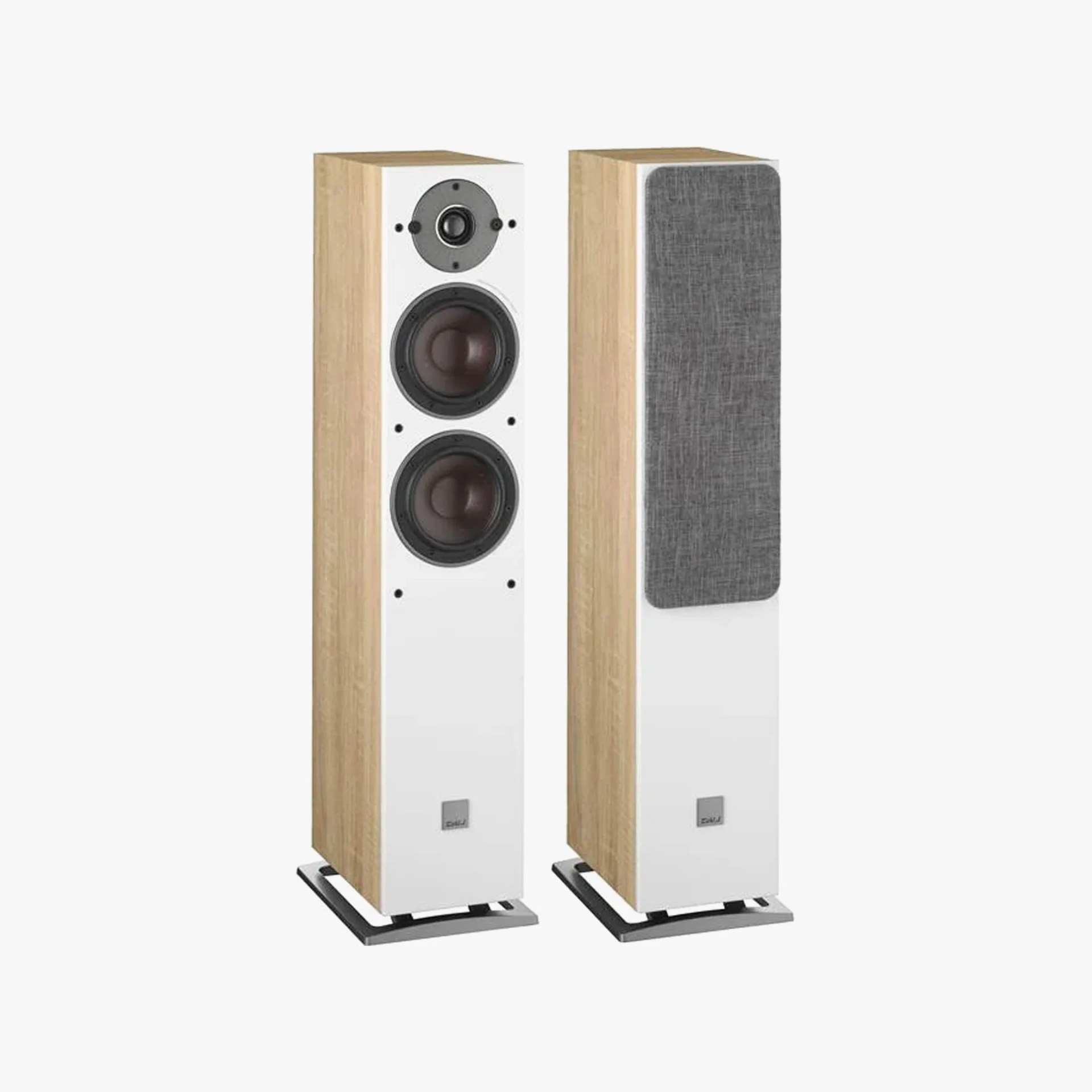 Pair of floor-standing speakers with light wood sides, white front panels, black speaker cones, and one covered with a gray fabric grille.