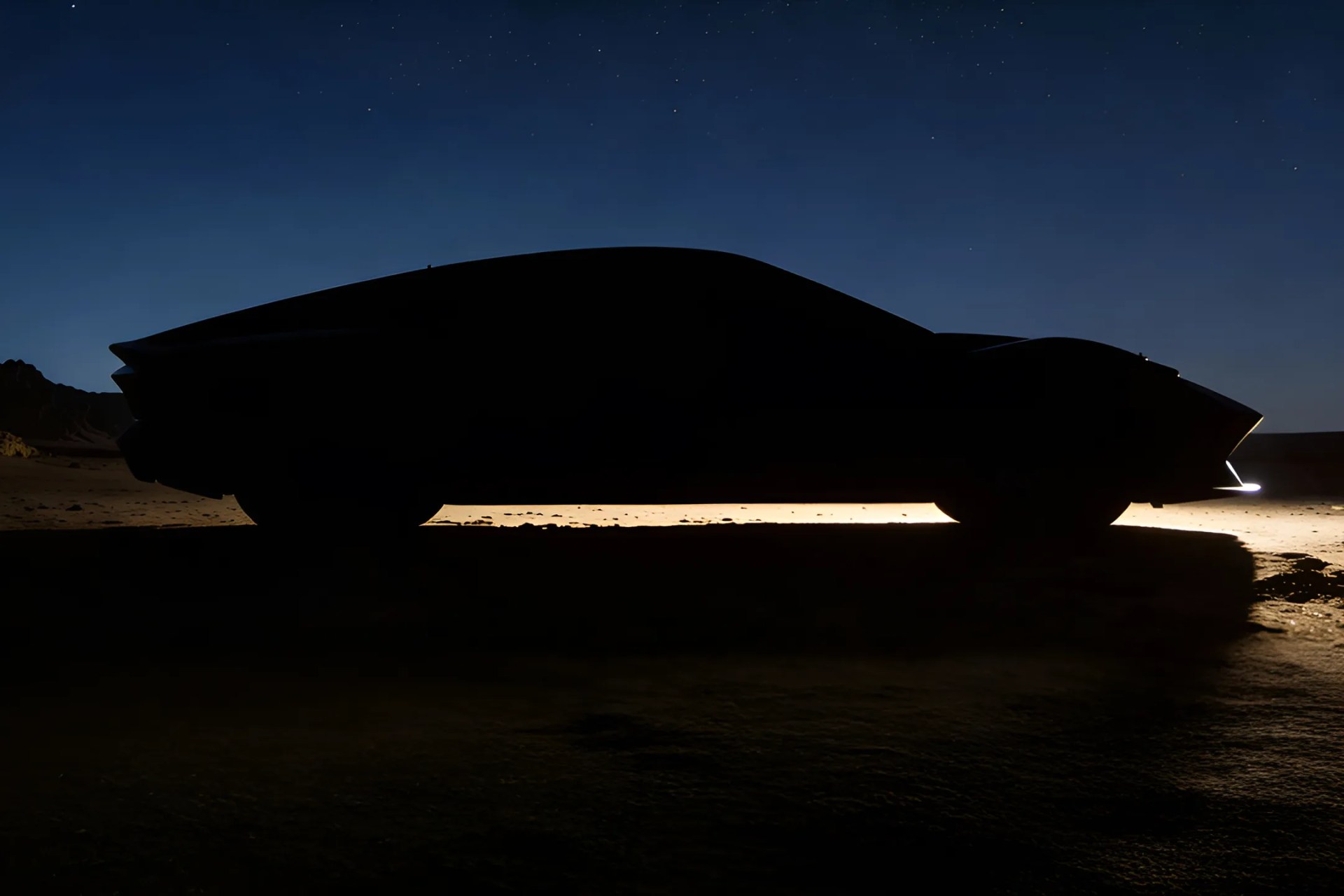 Silhouette of a sleek, low-profile car with illuminated outline and headlights against a twilight sky.