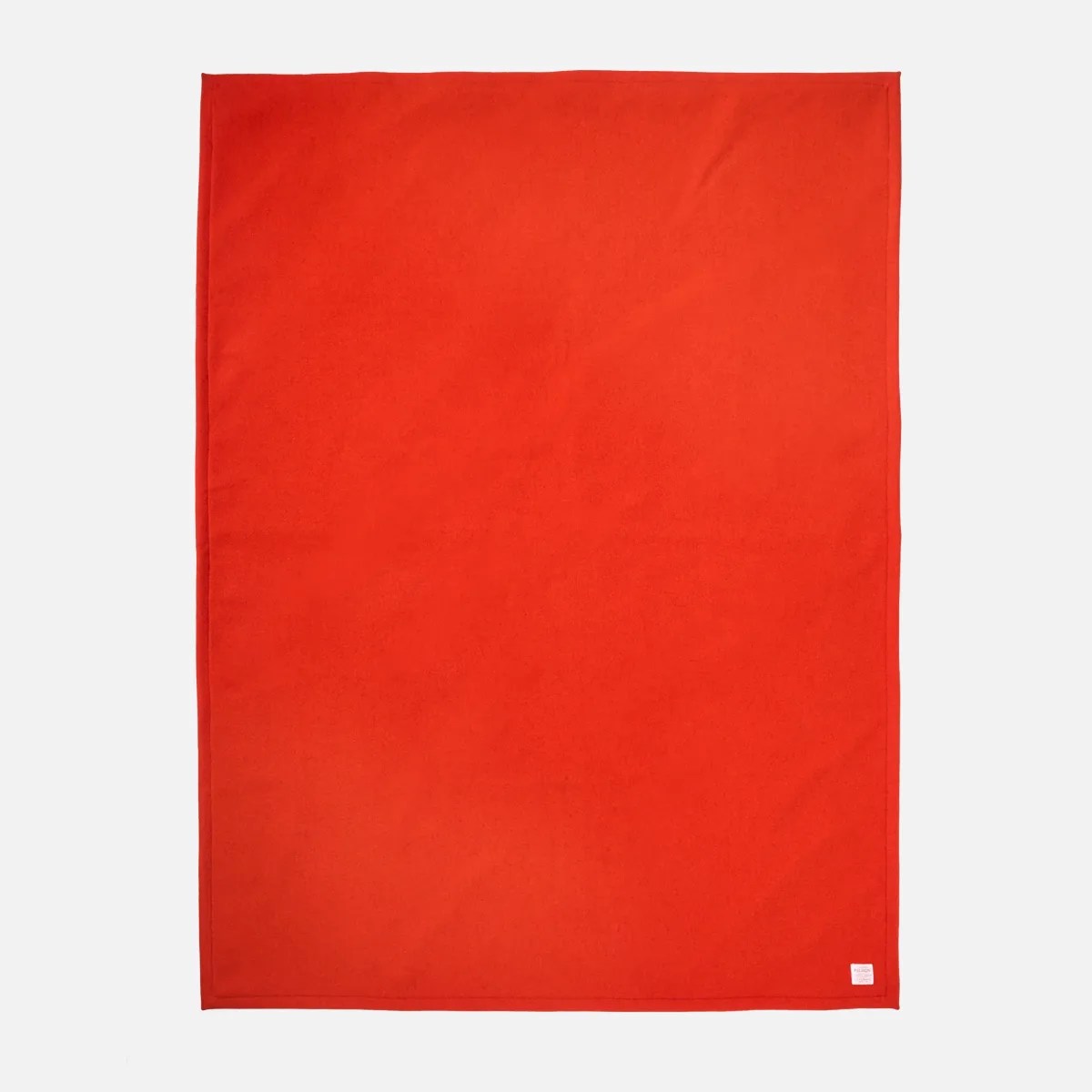 Bright red rectangular wool blanket with a small white label in the bottom right corner.