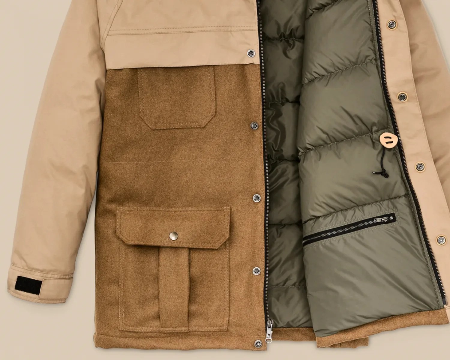 Beige and brown jacket with snap buttons, zippered front, flap pockets, and quilted olive-green interior lining.