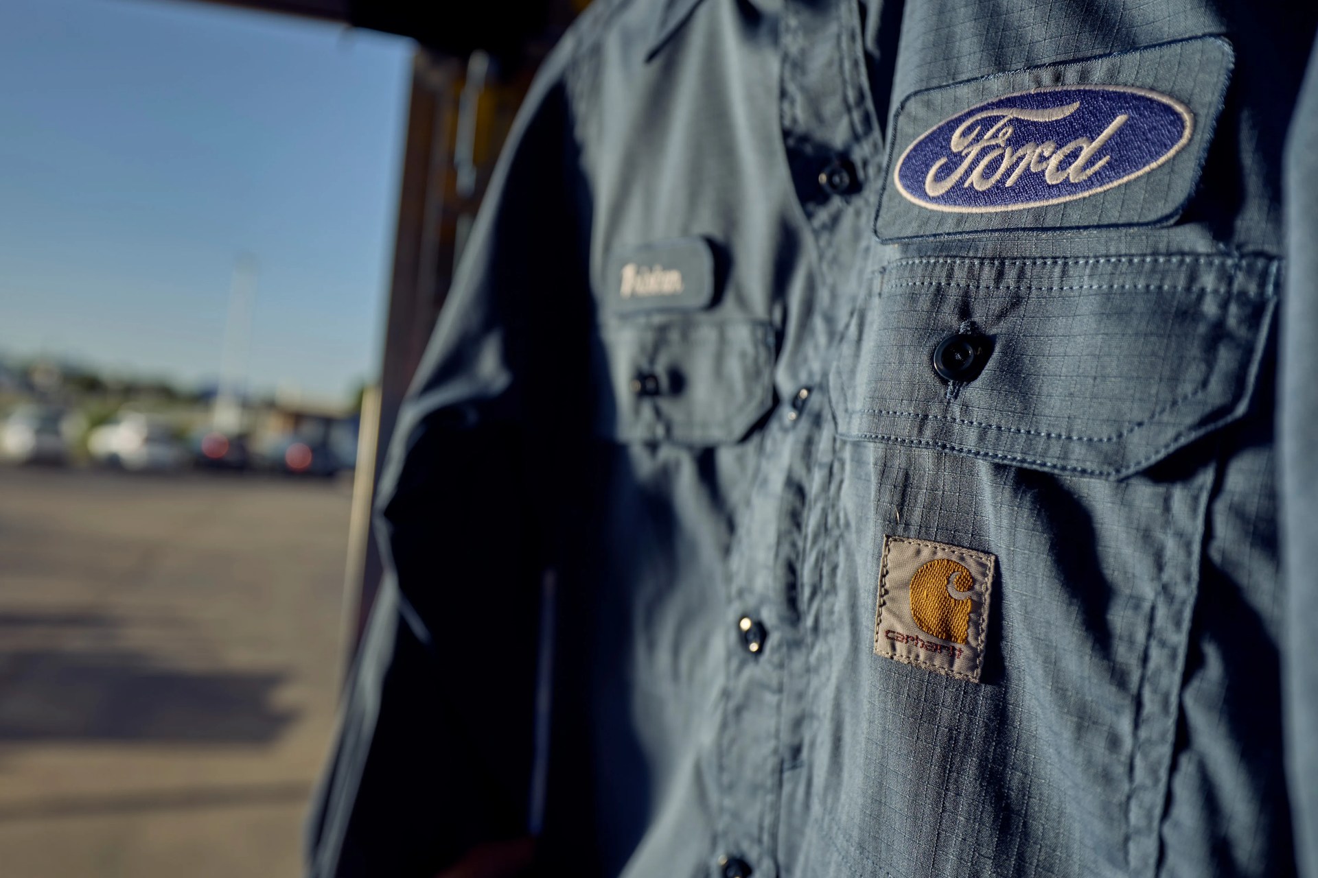 Blue work shirt with Ford and Carhartt logo patches on chest pockets.
