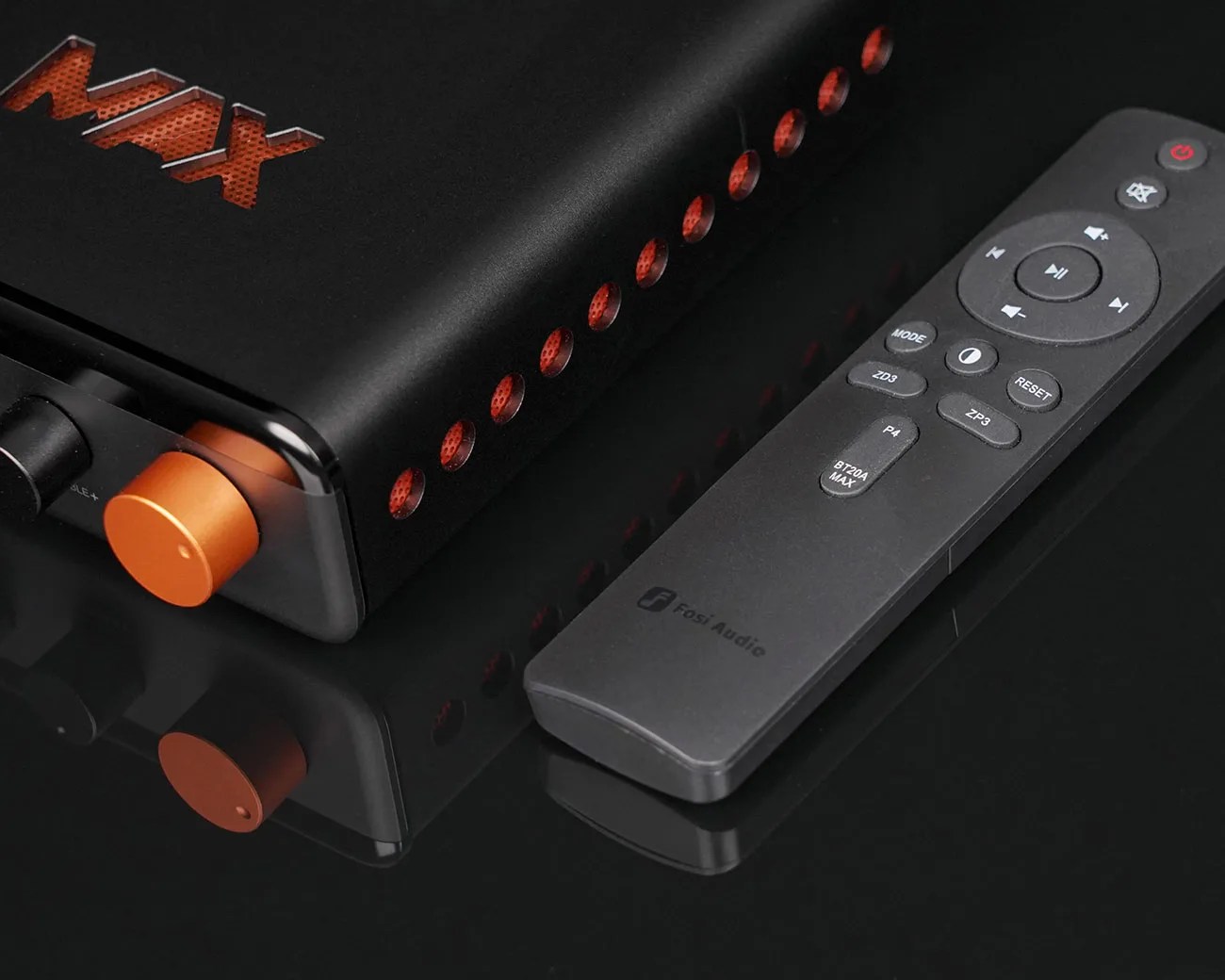 Black and orange Fosi Audio amplifier with matching black remote control on a reflective black surface.