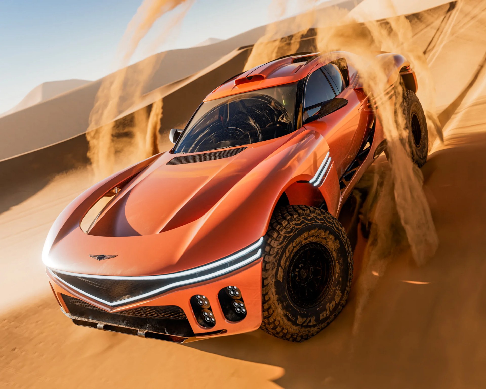 Orange off-road sports car kicking up sand on desert dunes under clear sky.