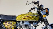 Yellow and maroon swirled Honda 350 motorcycle fuel tank and side cover with black seat and chrome engine parts.